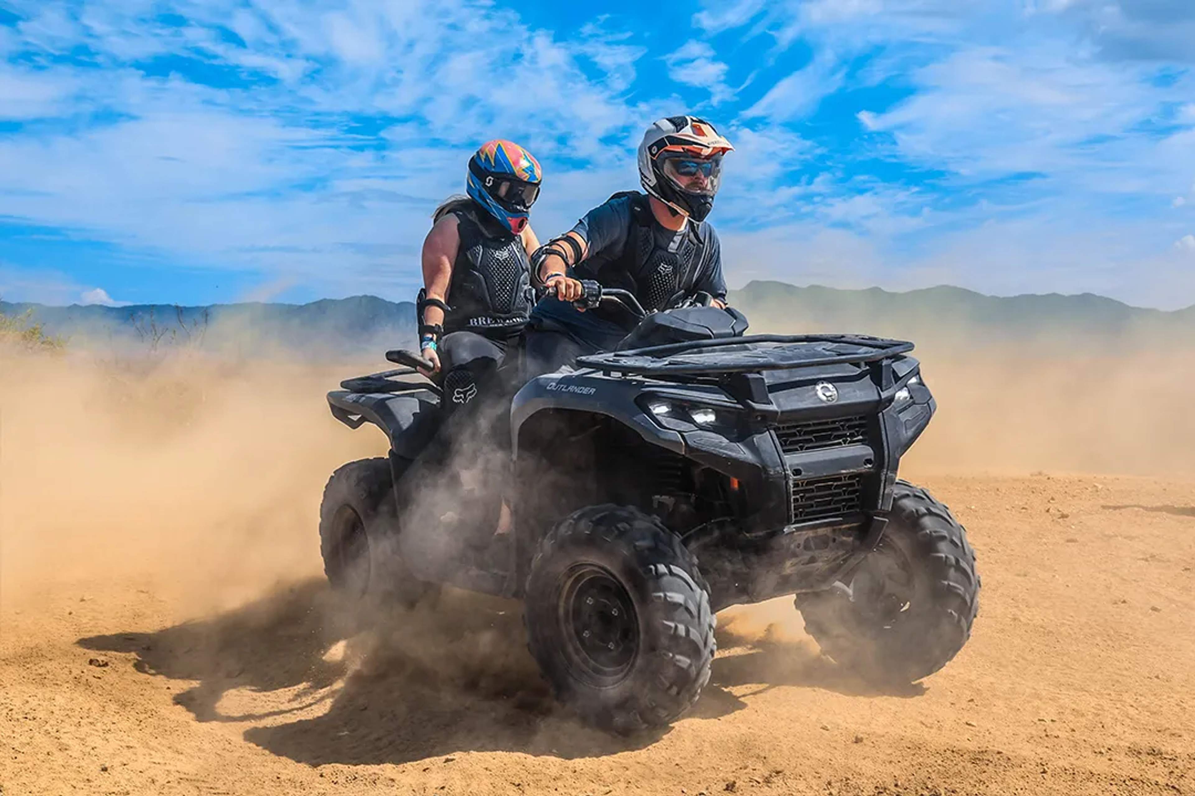 Couple riding an ATV through the Baja desert in Los Cabos, sharing adrenaline and adventure together