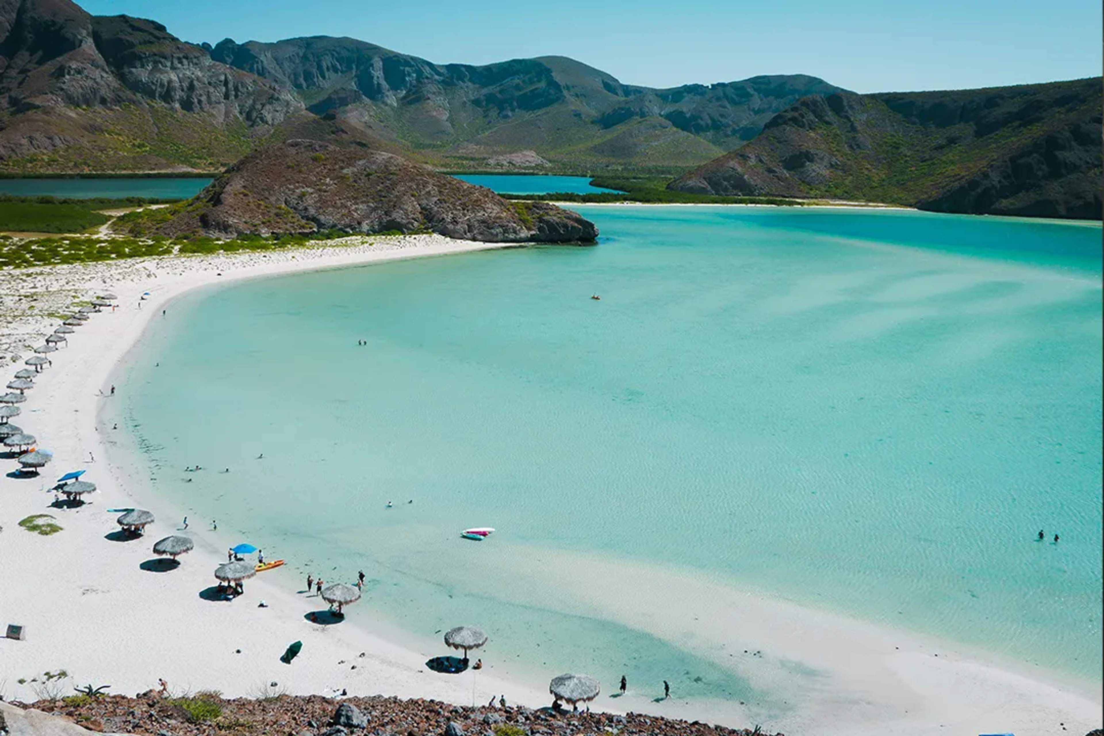 Playa Balandra en La Paz con aguas turquesa poco profundas, playa de arena blanca y colinas desérticas