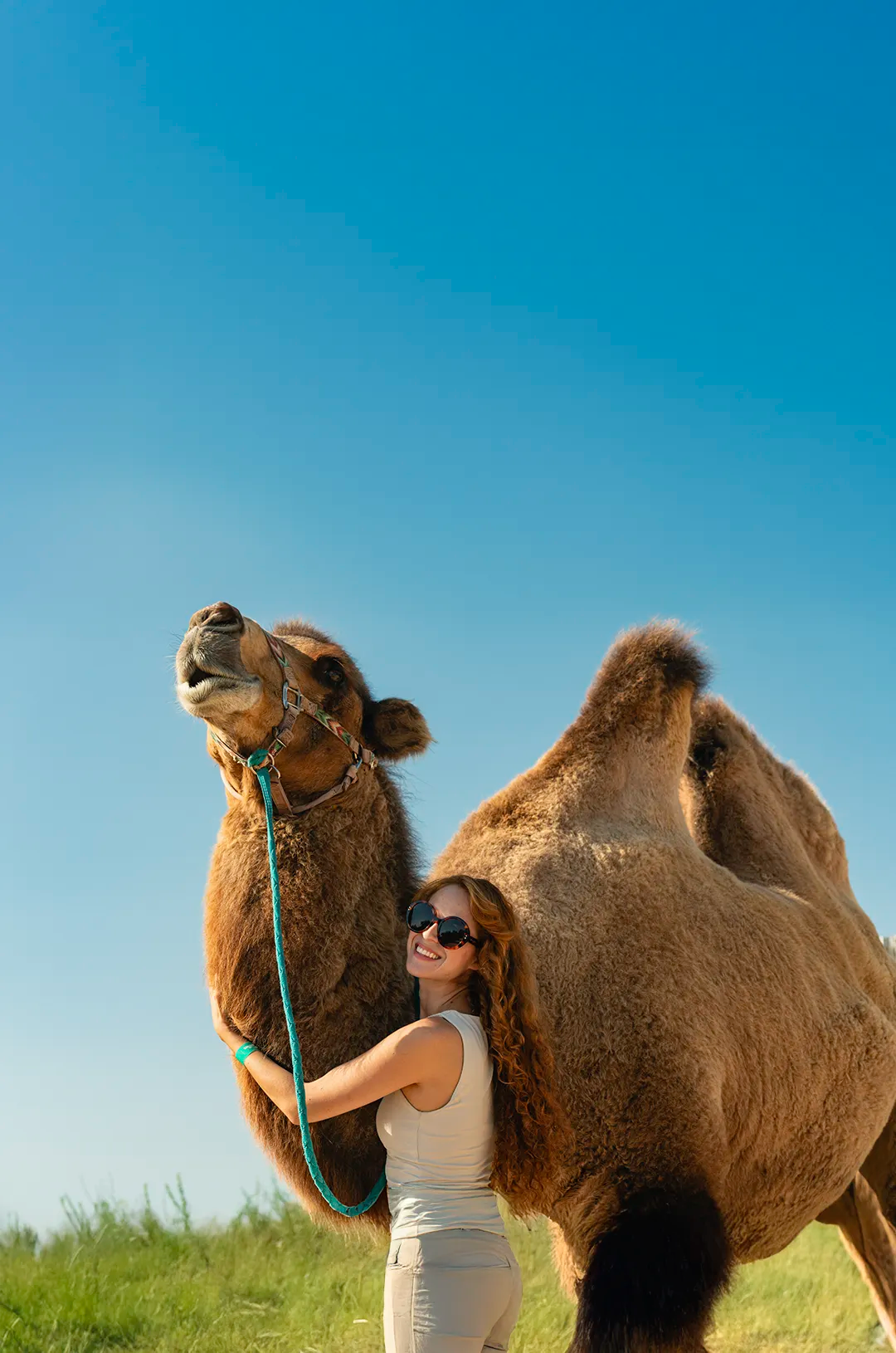 Woman enjoying a close encounter with a friendly camel at Tierra Sagrada, Cabo — a unique desert adventure experience.