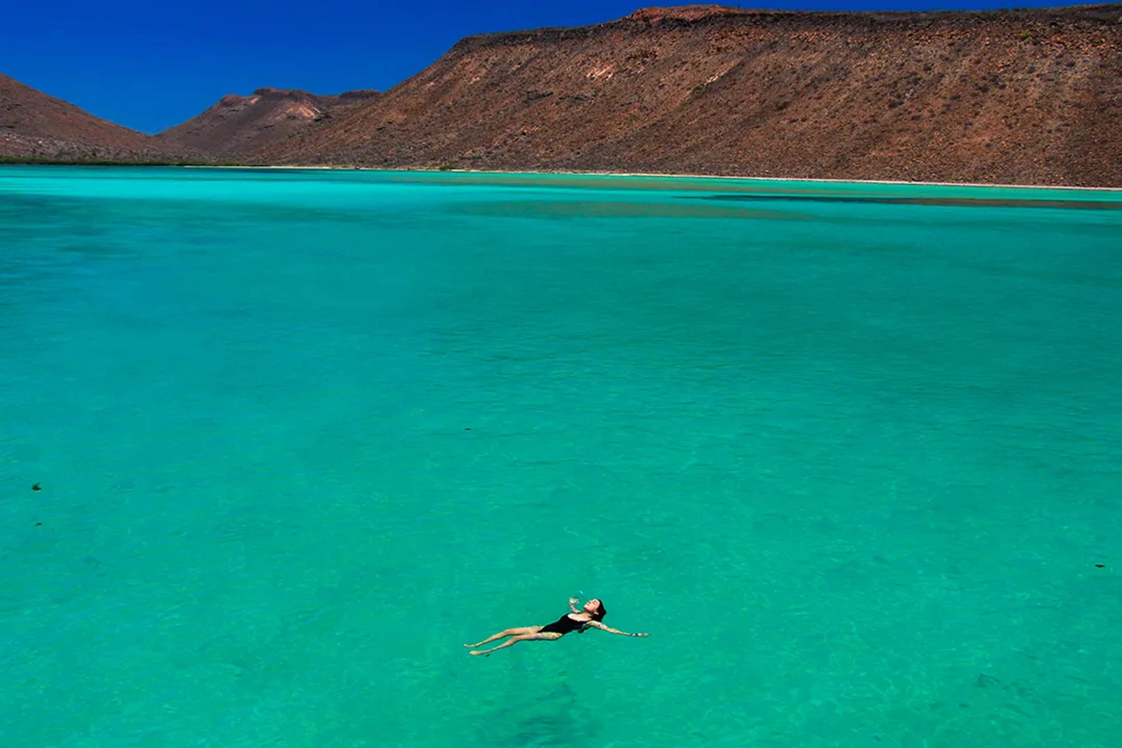 Woman floating in turquoise waters at Balandra Beach, La Paz—Mexico’s most beautiful natural lagoon.