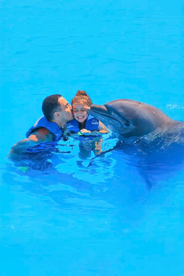 Family enjoying a dolphin swim experience in Cabo San Lucas.