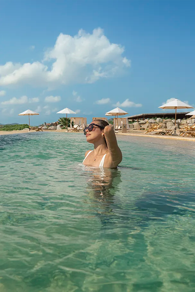 Woman enjoying the pool at Tierra Sagrada Beach Club, Los Cabos, Mexico.