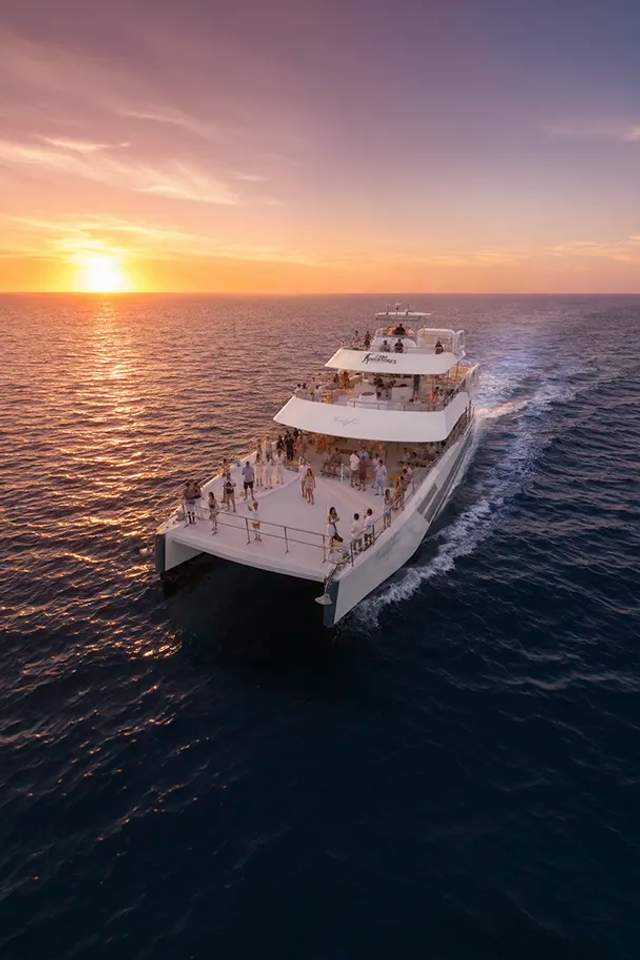 Guests dancing and having fun at a Cabo Party Boat at sunset.