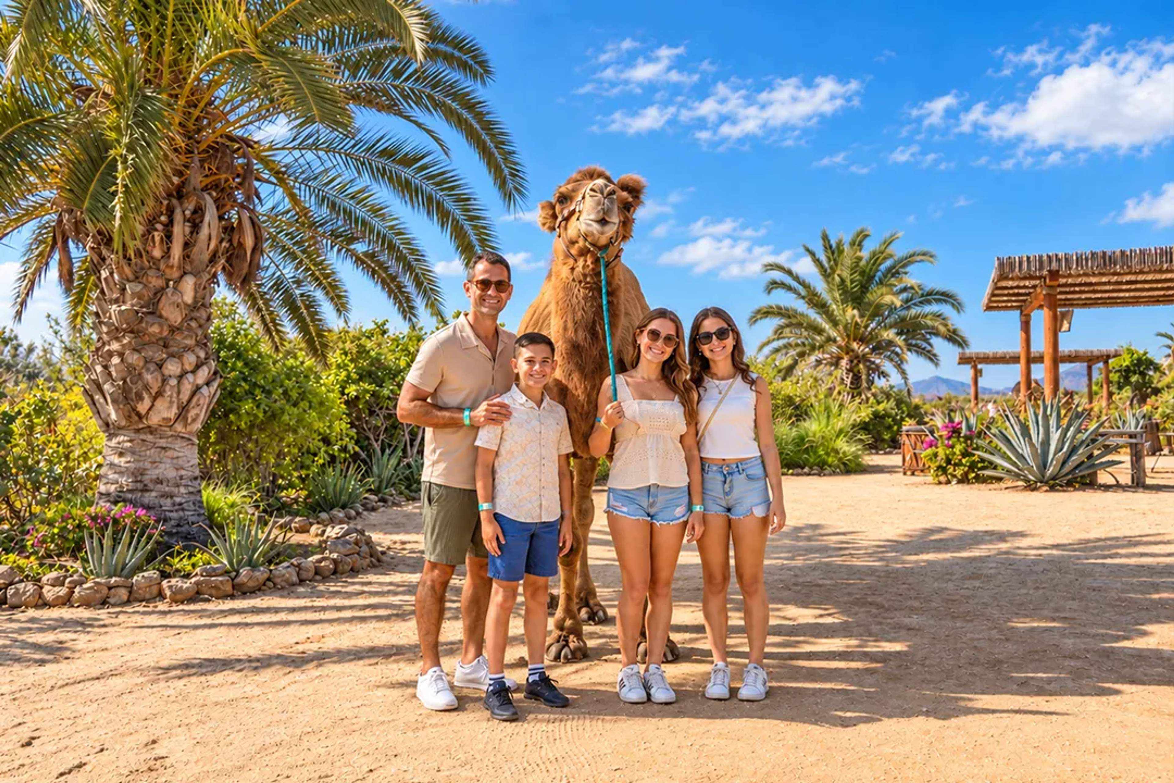 Familia posando con un camello en Tierra Sagrada durante una experiencia de Cabo Adventures en Los Cabos.