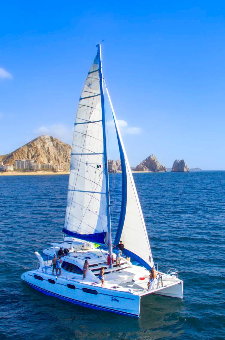 Cabo catamaran sailing the waters near the Arch of Cabo San Lucas.