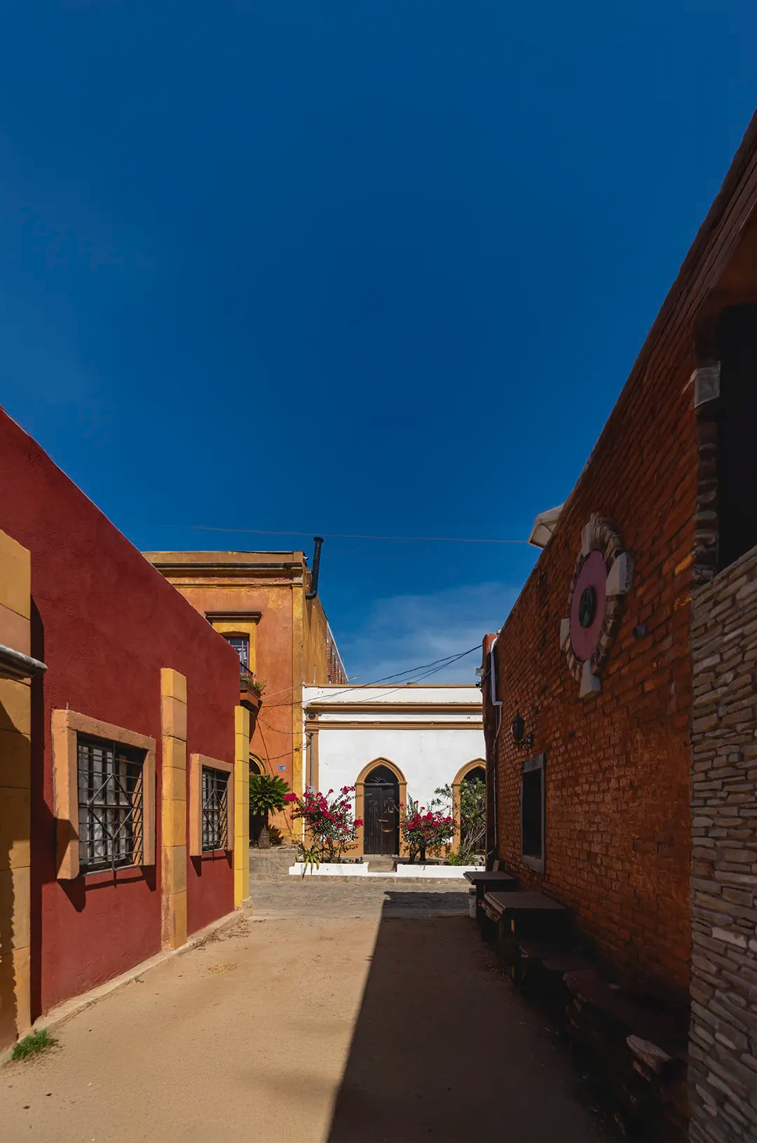 Callejón histórico y colorido en El Triunfo, Baja California Sur, con edificios restaurados, texturas y encanto local.
