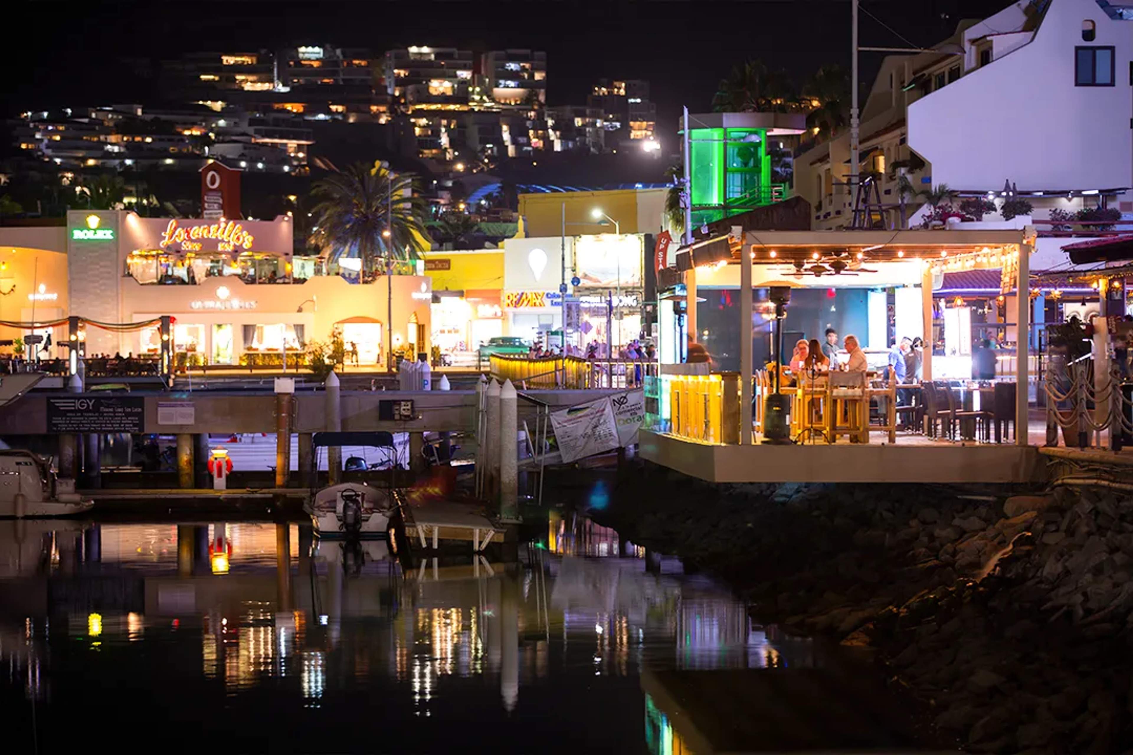 Cabo San Lucas marina at night with waterfront restaurants, lights, and vibrant nightlife by the harbor