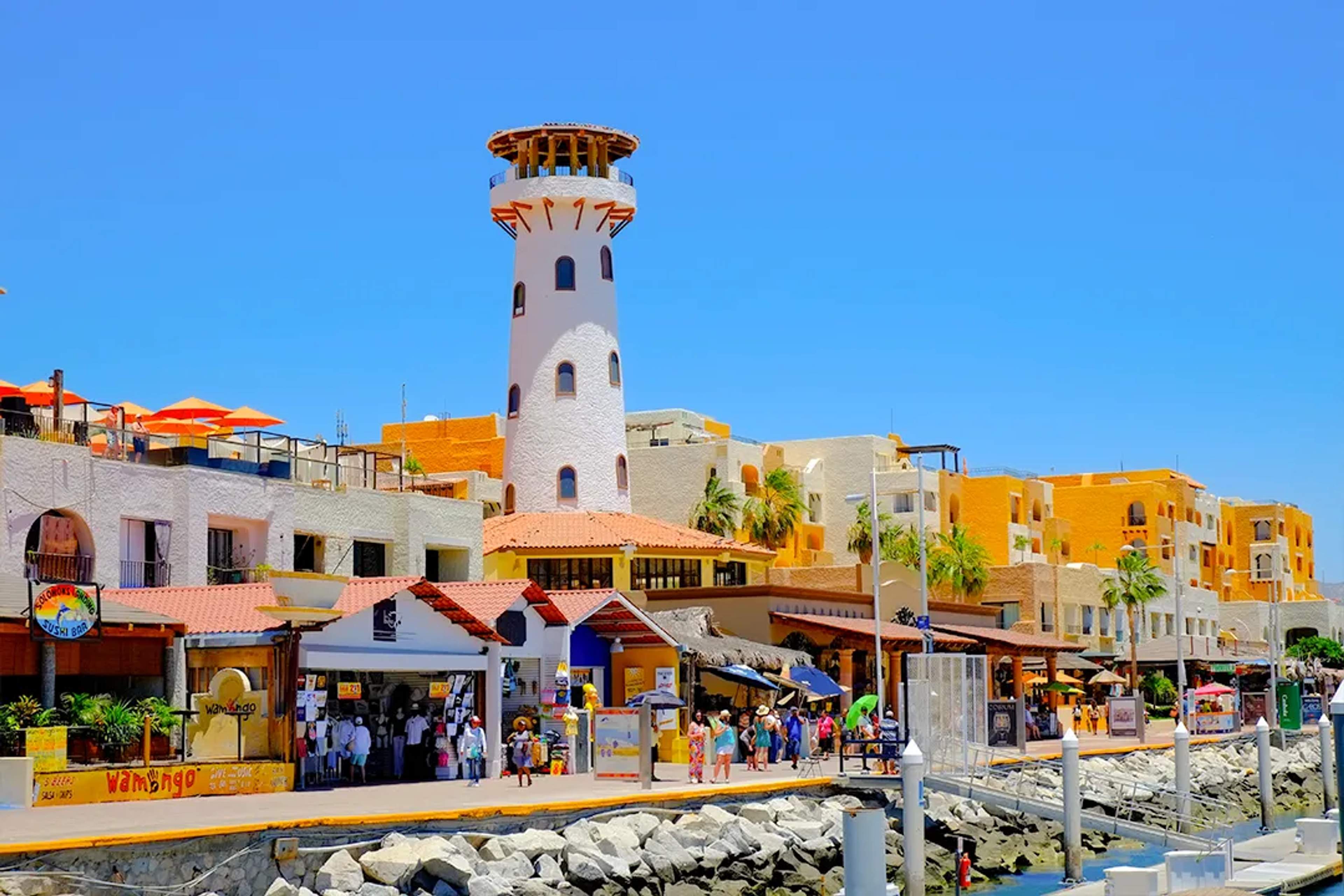 Cabo San Lucas Marina with lighthouse, shops and waterfront promenade near top boat tour departure docks