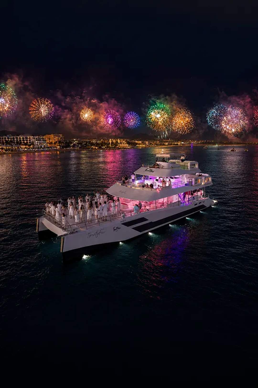 New Year’s Eve Golden Midnight aboard TwentyFive catamaran by Cabo Adventures with fireworks over Cabo San Lucas Bay.