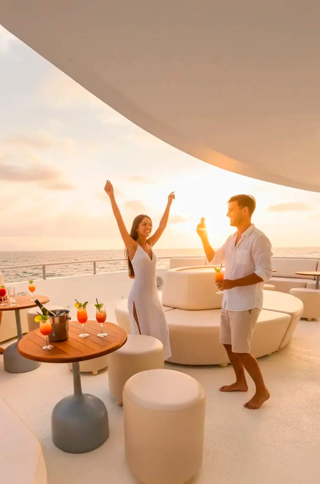 Pasajeros disfrutando cócteles y vistas al atardecer en un catamarán de lujo en Los Cabos.