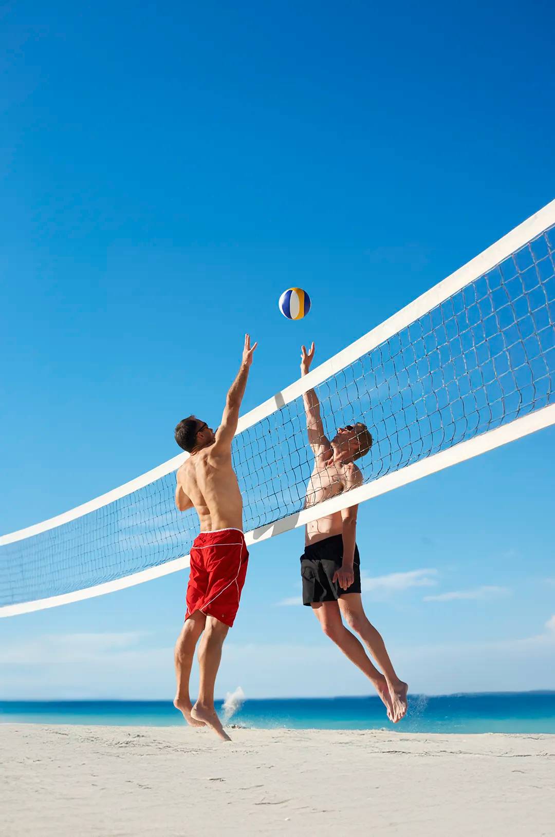 Beach volleyball game with friends under blue sky at Tierra Sagrada Adventure Park in Cabo