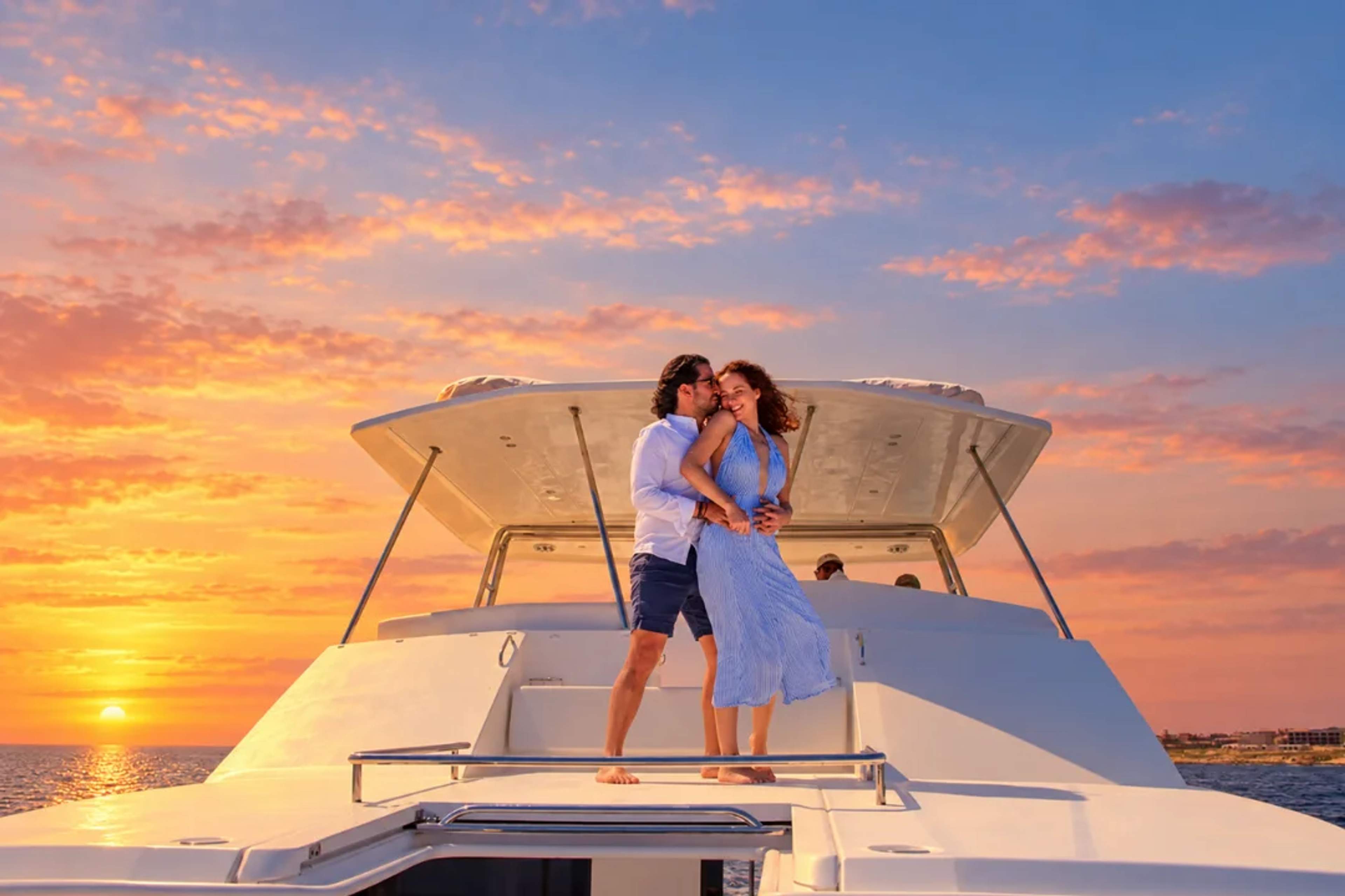Romantic couple on a Cabo Adventures catamaran at sunset in Cabo.
