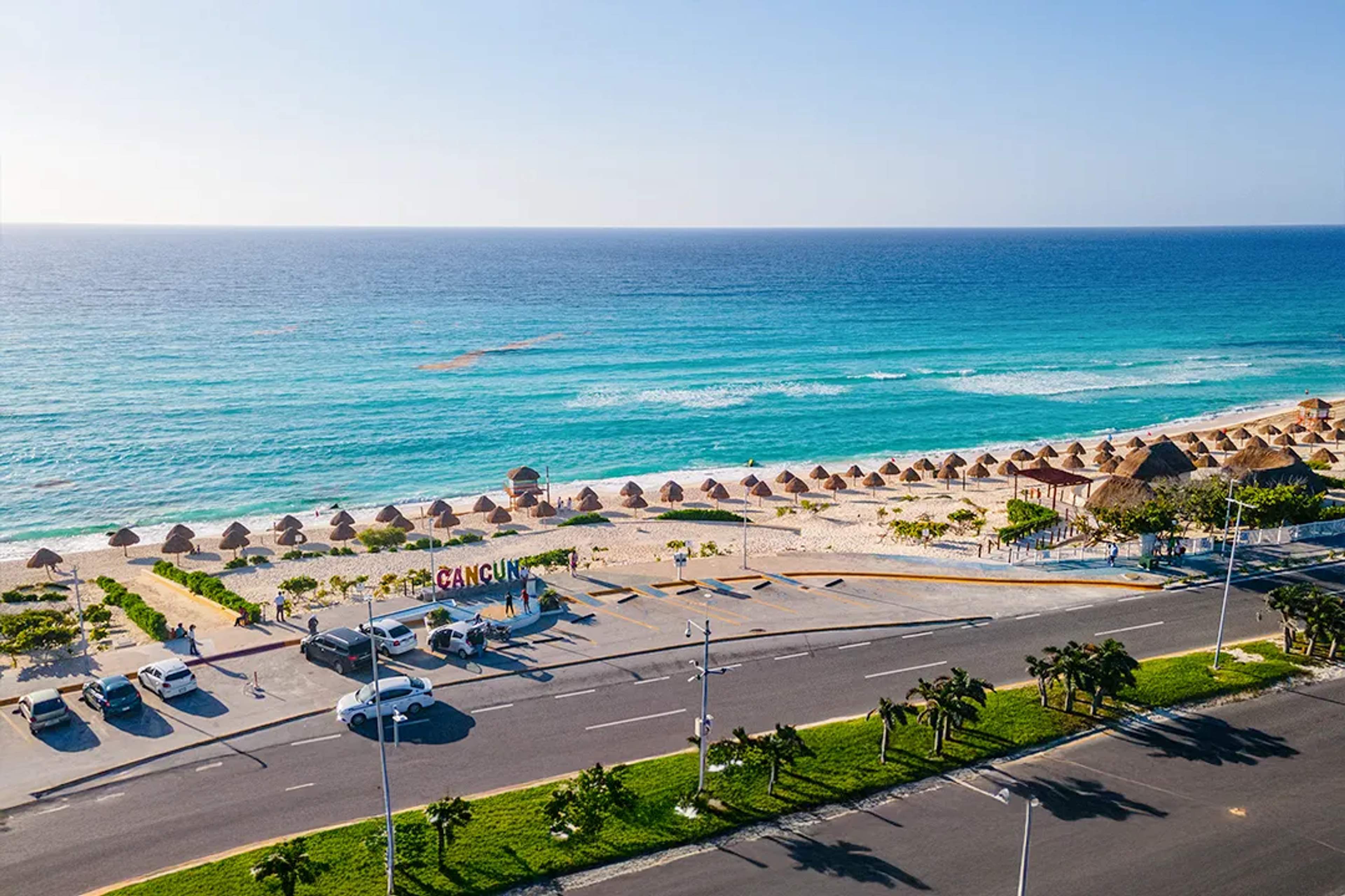 Vista aérea de Playa Delfines en Cancún con arena blanca y mar Caribe turquesa en un día soleado