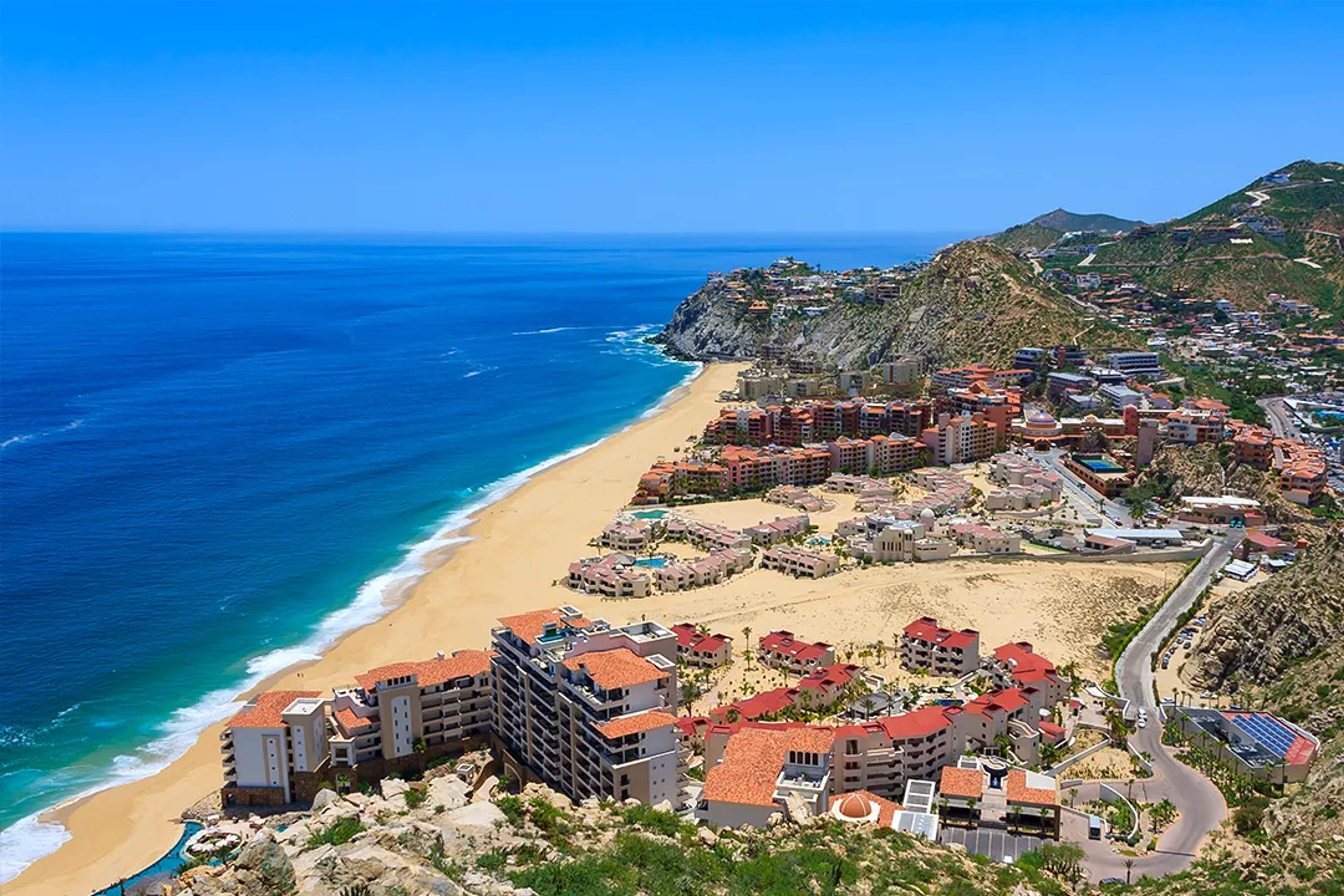 Vista aérea de resorts de lujo y playas doradas en Cabo San Lucas junto al Mar de Cortés