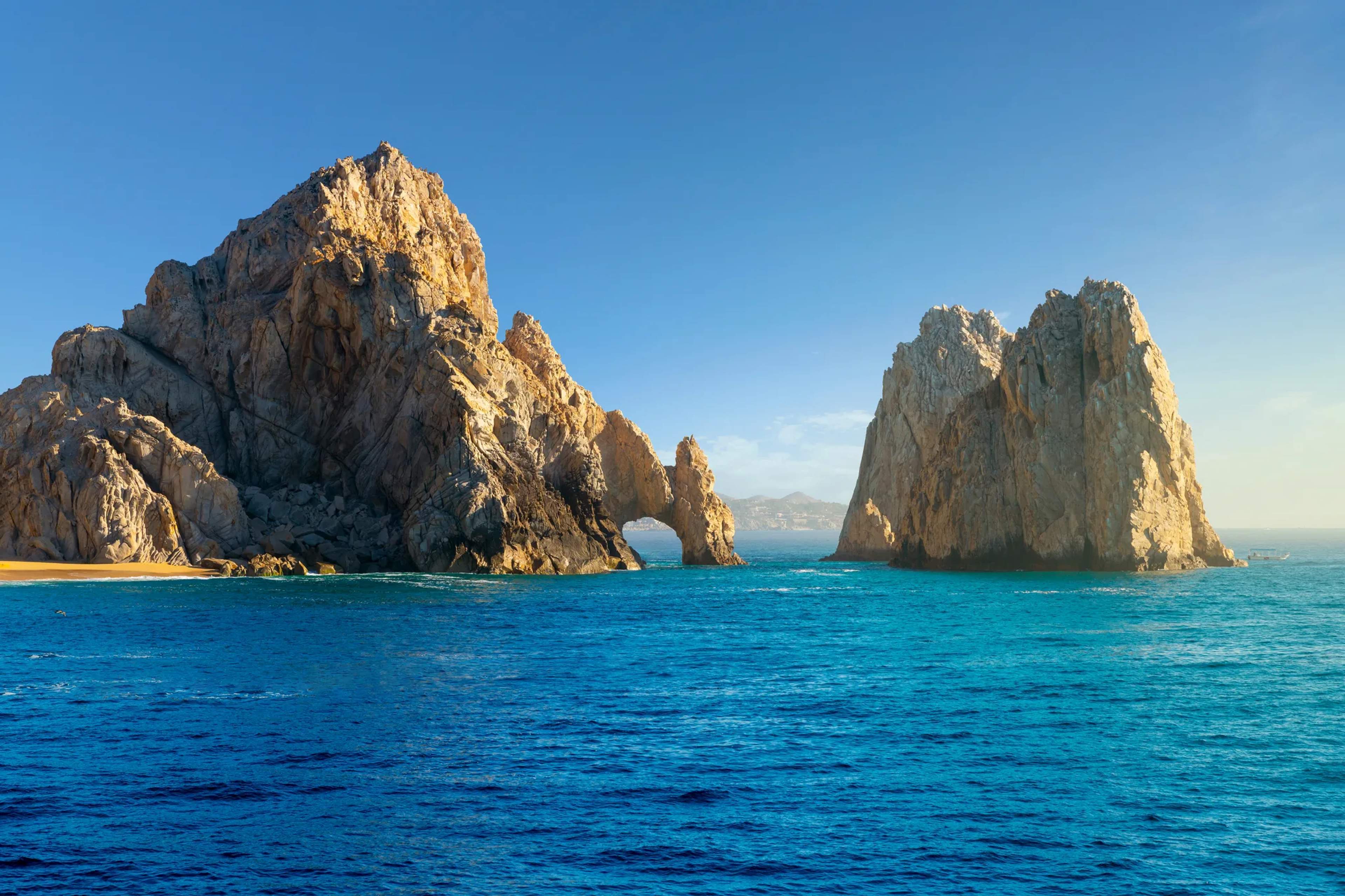 El Arco rises from turquoise Pacific waters under clear blue skies at Land's End, Cabo San Lucas.
