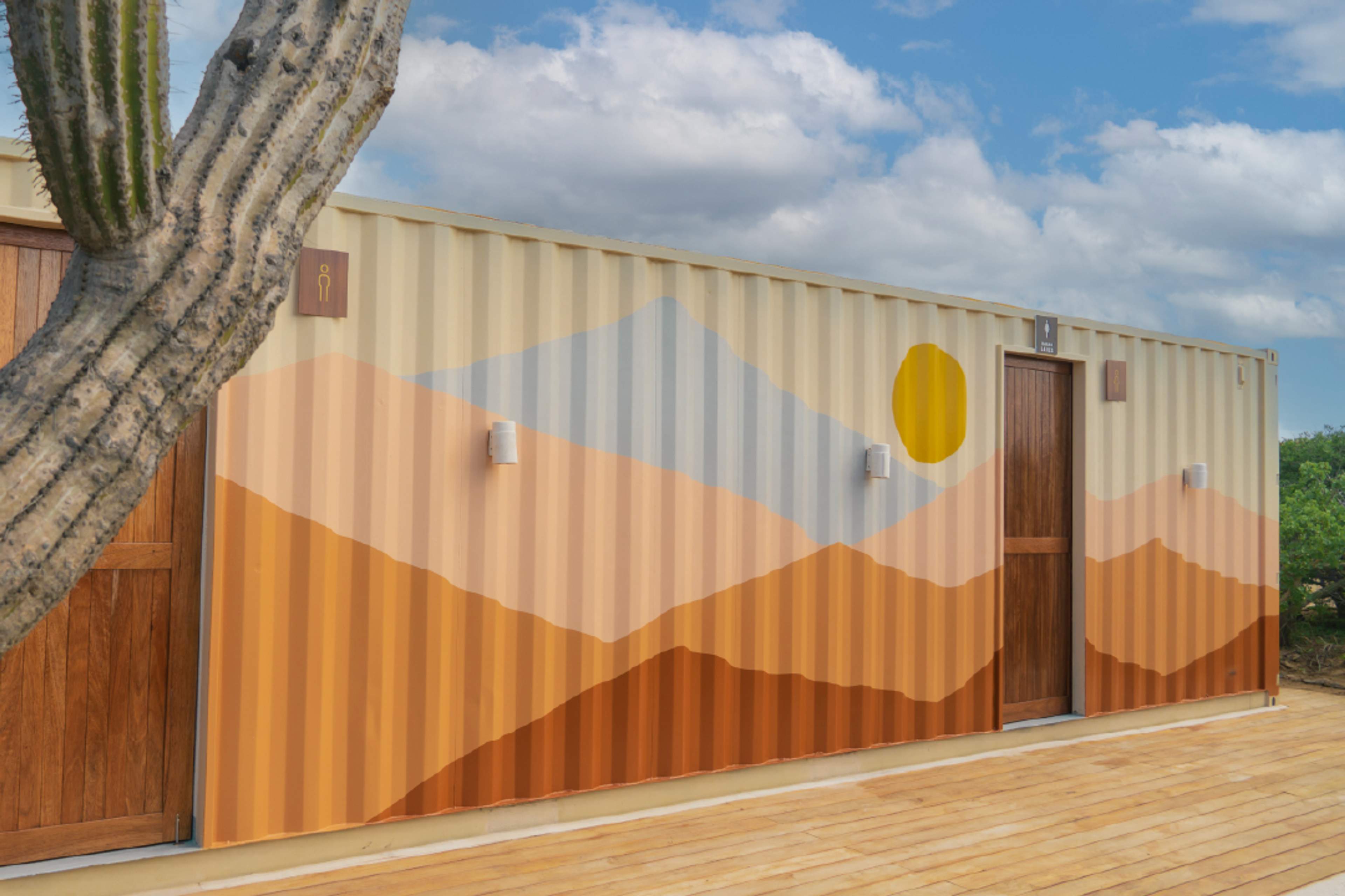 Colorful desert mural on restroom wall at Tierra Sagrada Beach Club, Instagram spot in Cabo