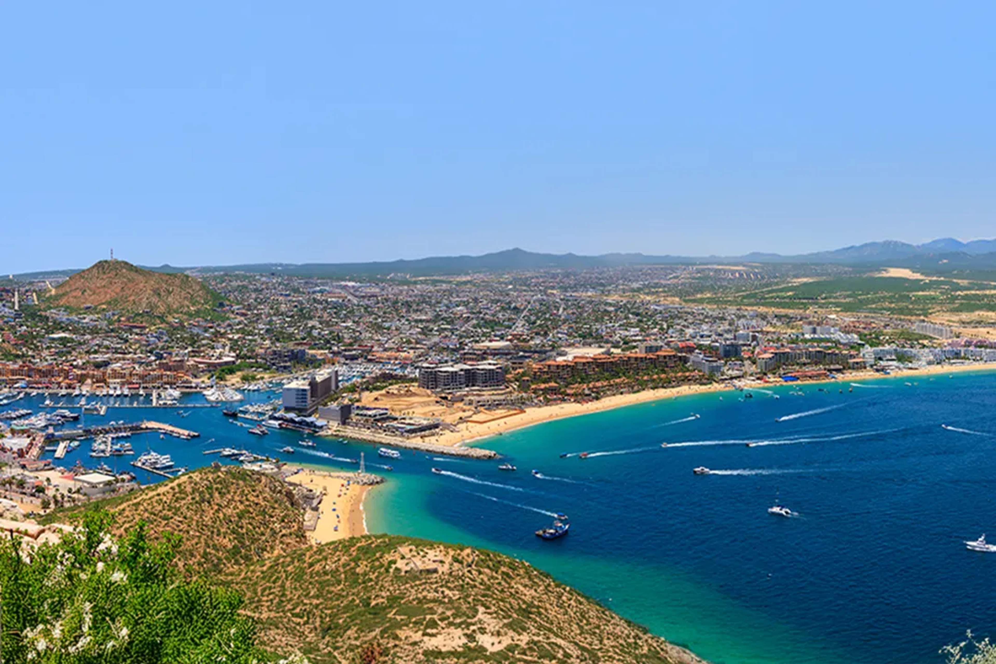 Aerial view of Cabo San Lucas marina and Medano Beach with turquoise Sea of Cortez during scenic boat tour day