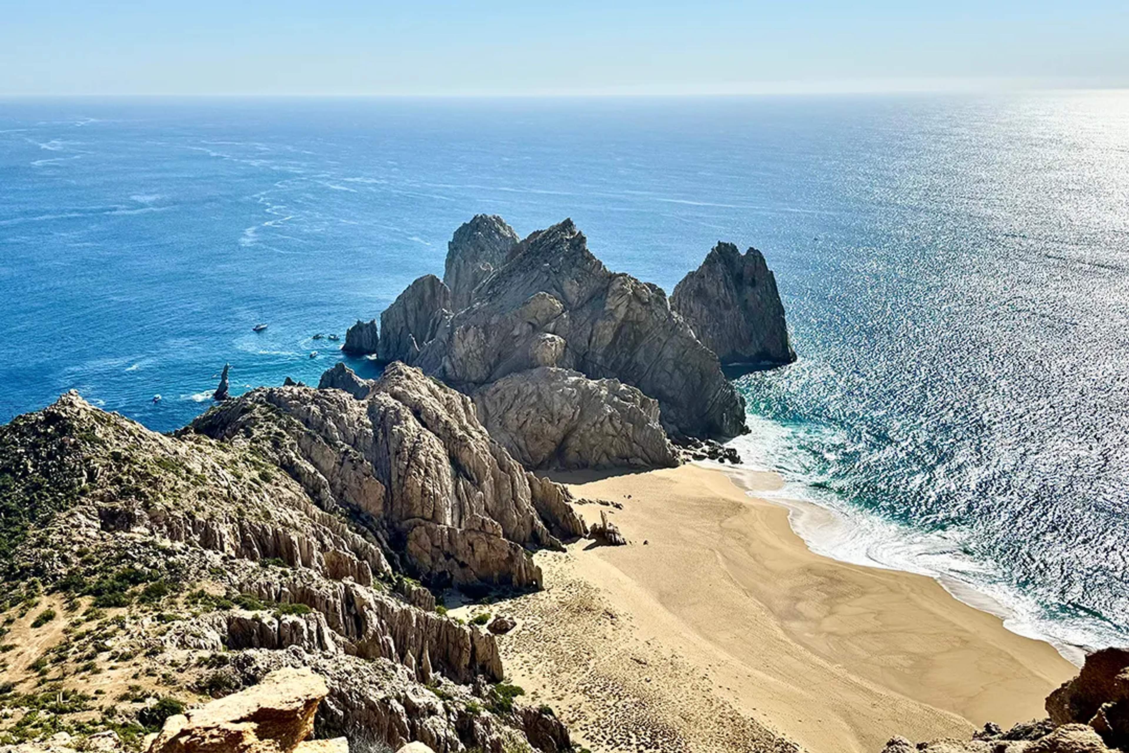 Scenic view of Cabo’s rock formations and golden beach meeting the deep blue ocean.
