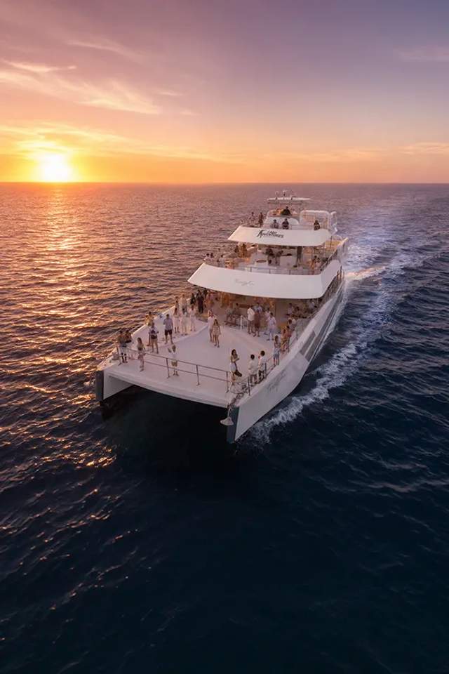 Guests dancing and having fun at a Cabo Party Boat at sunset.