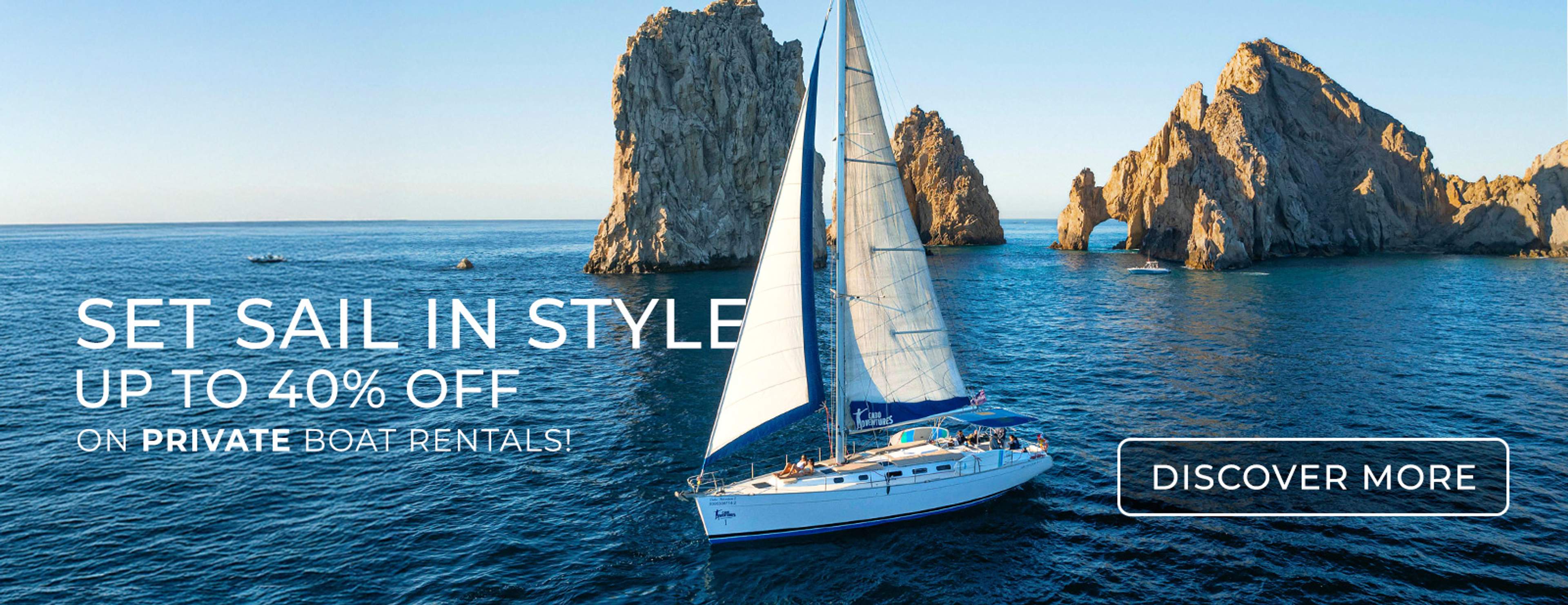Sailboat glides by Cabo’s iconic Arch; promo offers 40% off private rentals in May 2025.