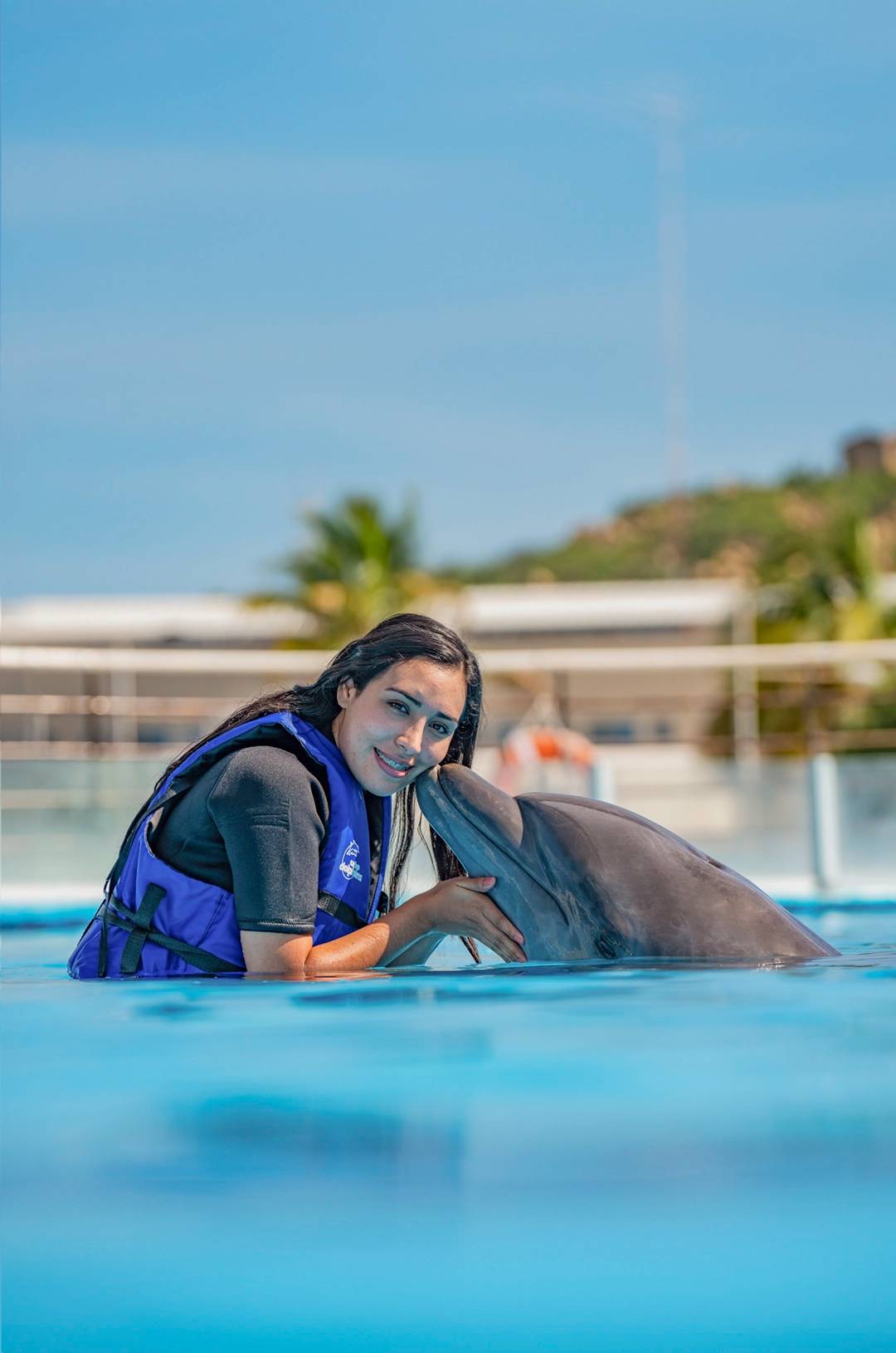Woman receiving a kiss from a dolphin during an experience in Cabo San Lucas.