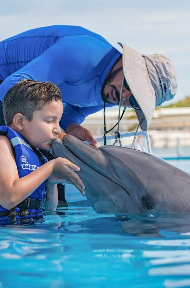 Child enjoying a Dolphin Encounter in Los Cabos with a Pacific bottlenose dolphin at Cabo Adventures