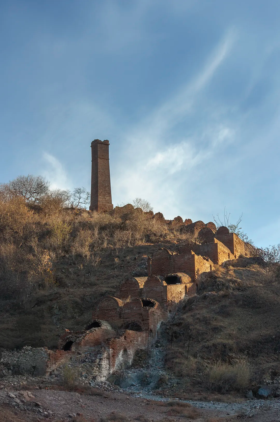 Visitantes recorren calles empedradas de El Triunfo, Baja California Sur, admirando edificios históricos restaurados.