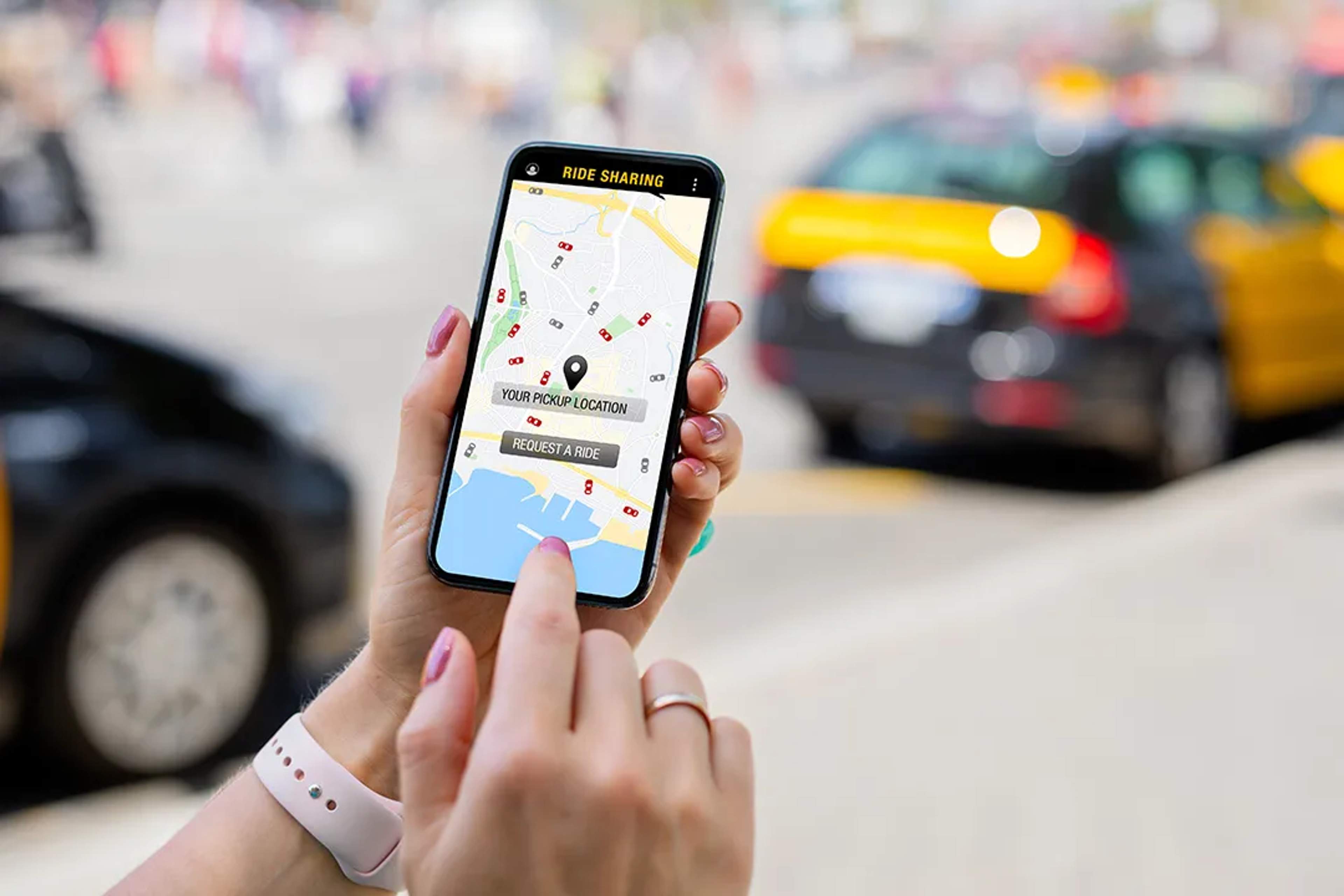 Woman using a ride-sharing app on her phone to request a ride in the city.