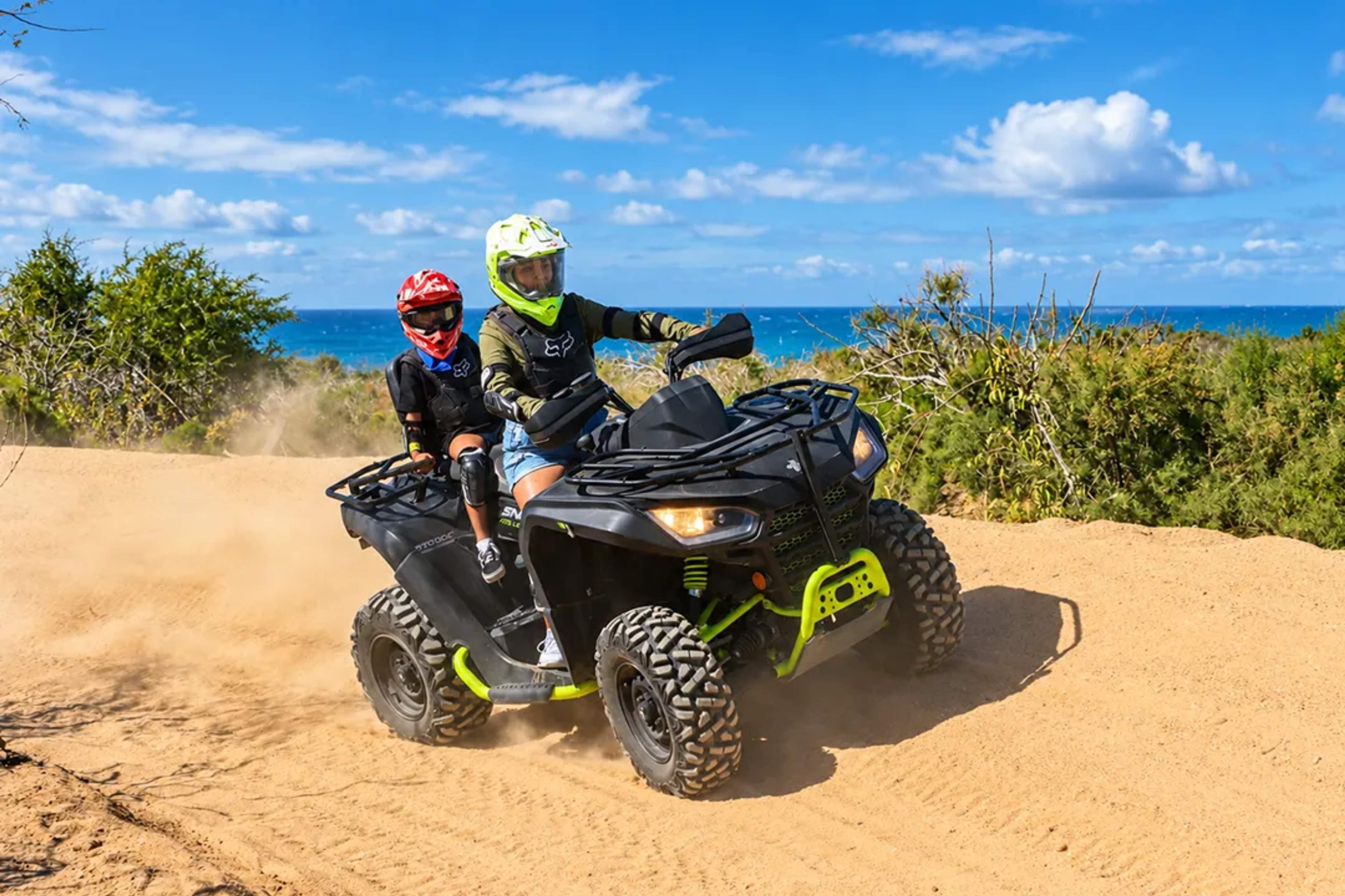 Family riding an ATV along a coastal desert trail with Cabo Adventures in Los Cabos.