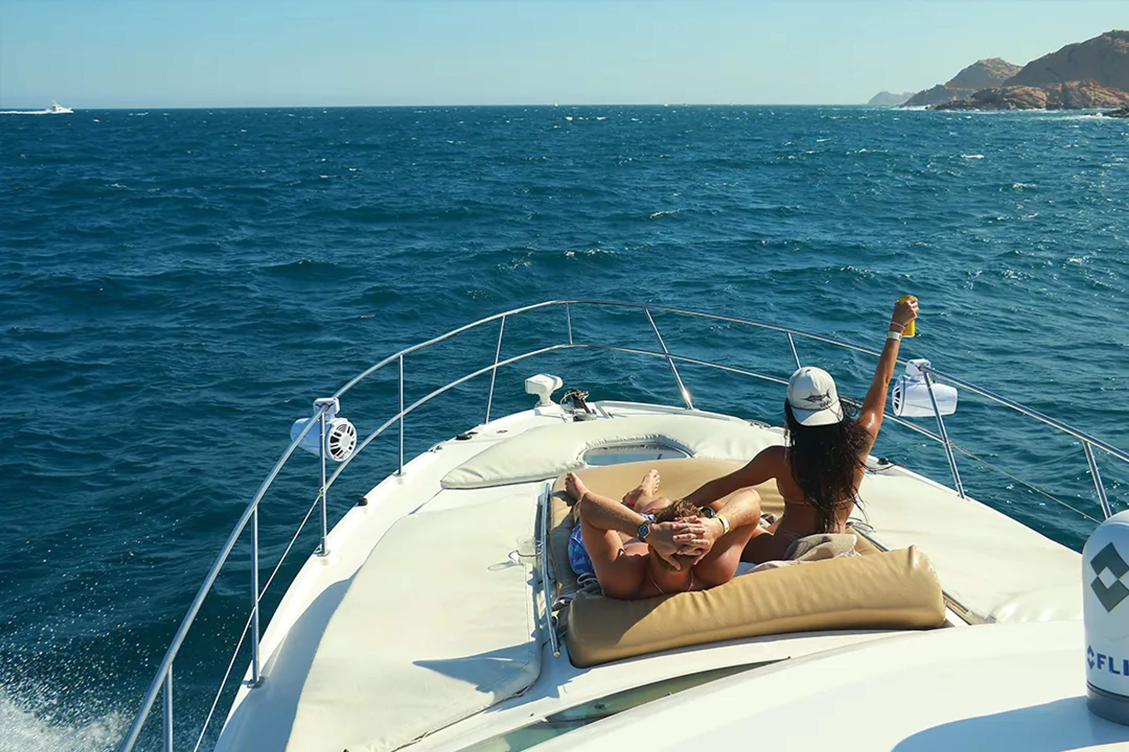 Luxury yacht tour in Cabo San Lucas with guests relaxing on deck, ocean views, open sea, and a private escape vibe