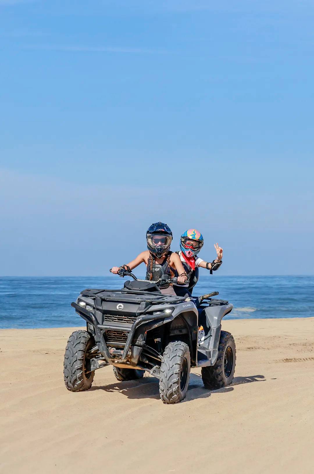 Two riders on an ATV enjoying an off-road beach adventure at Tierra Sagrada in Cabo San Lucas