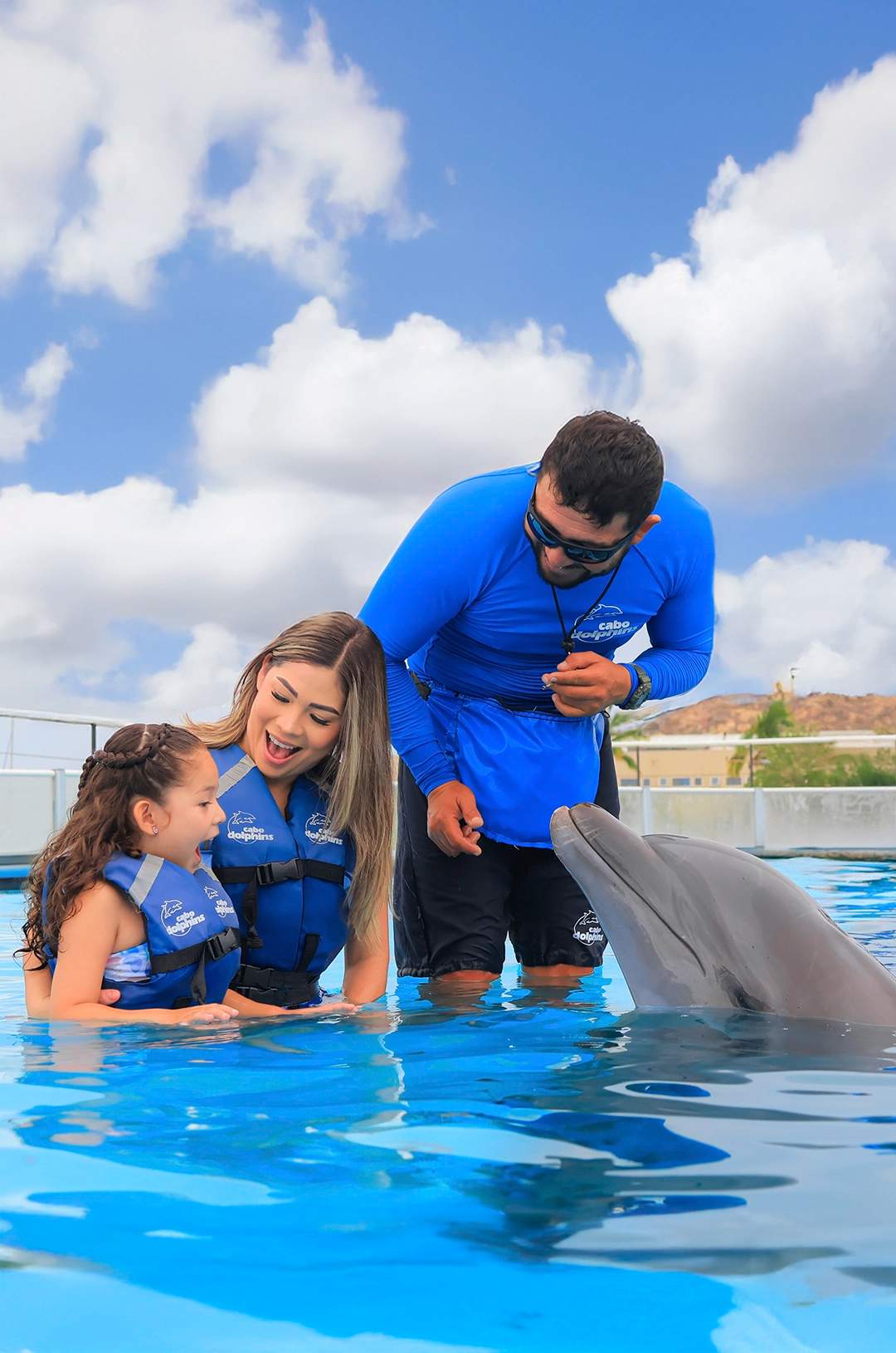 Family learning and interacting during a dolphin swim experience.