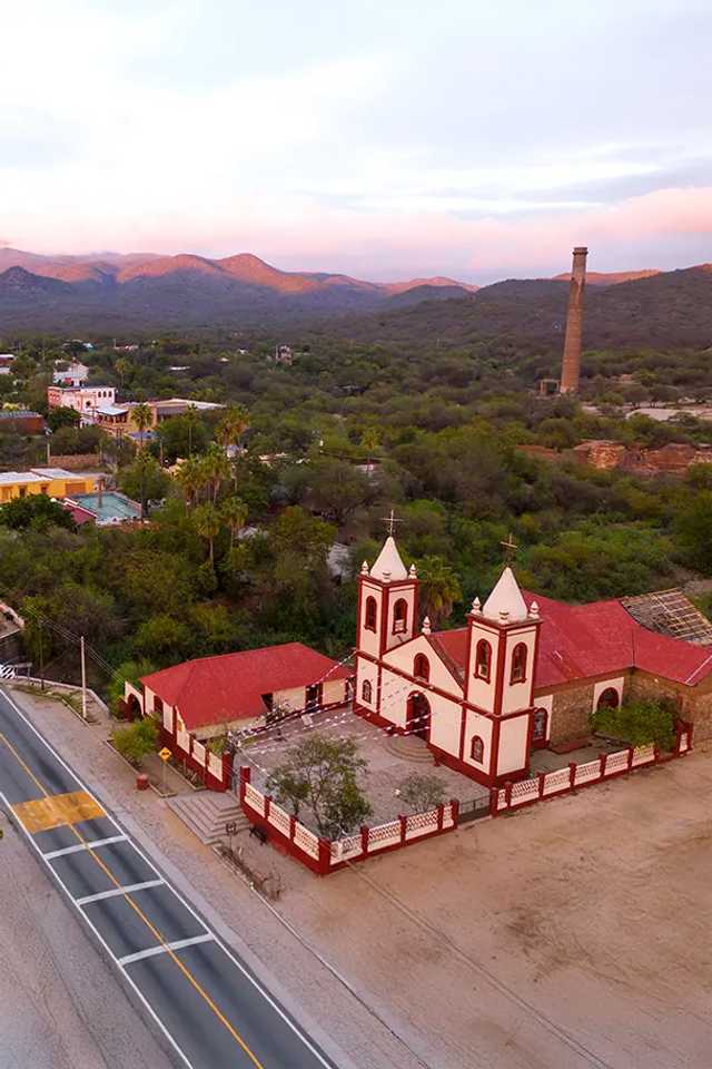 Vista aérea de El Triunfo, Baja California Sur, con su iglesia histórica, la chimenea La Ramona y paisajes montañosos.