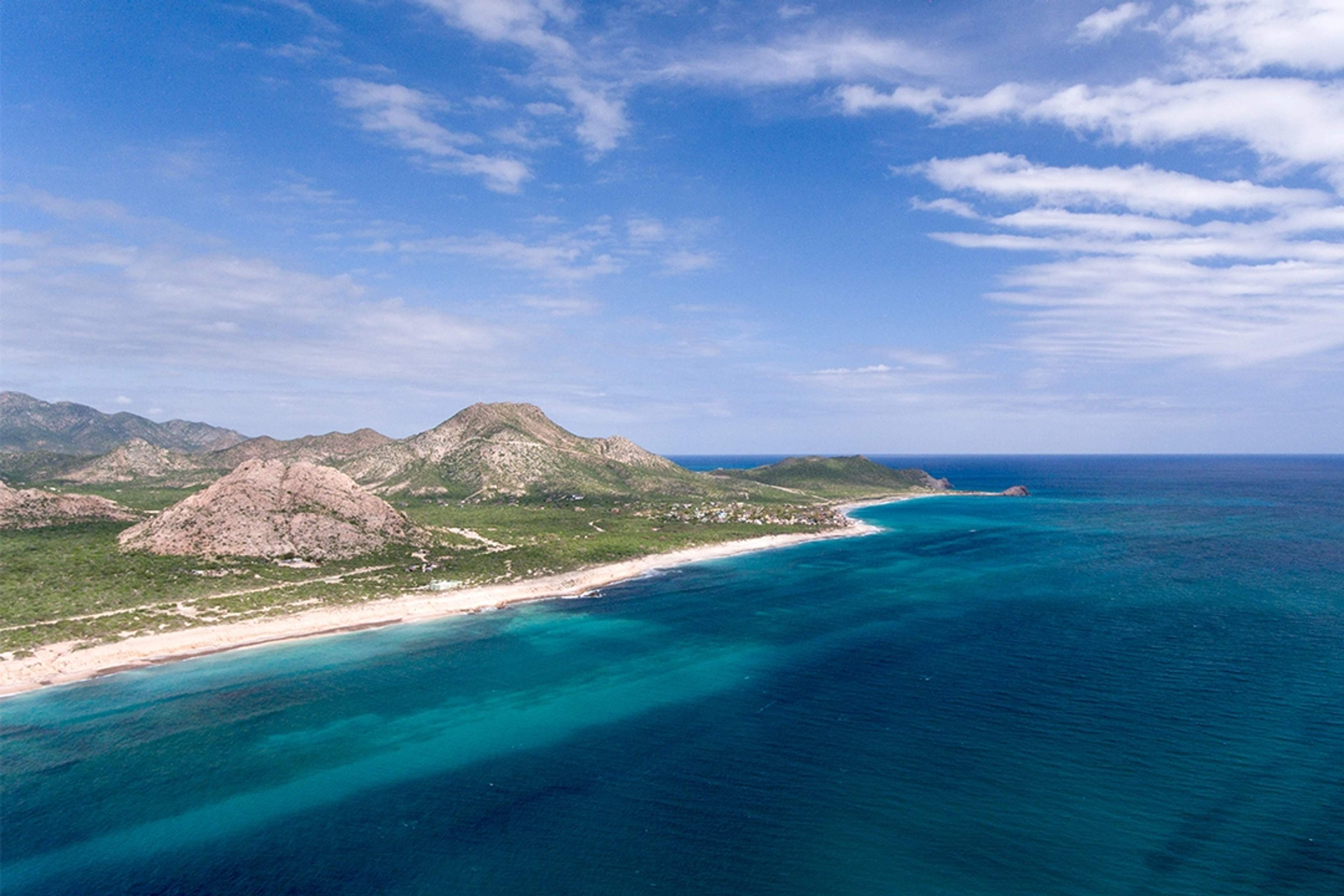Secluded beach with turquoise waters and surrounding hills in Cabo San Lucas, perfect for tranquility.