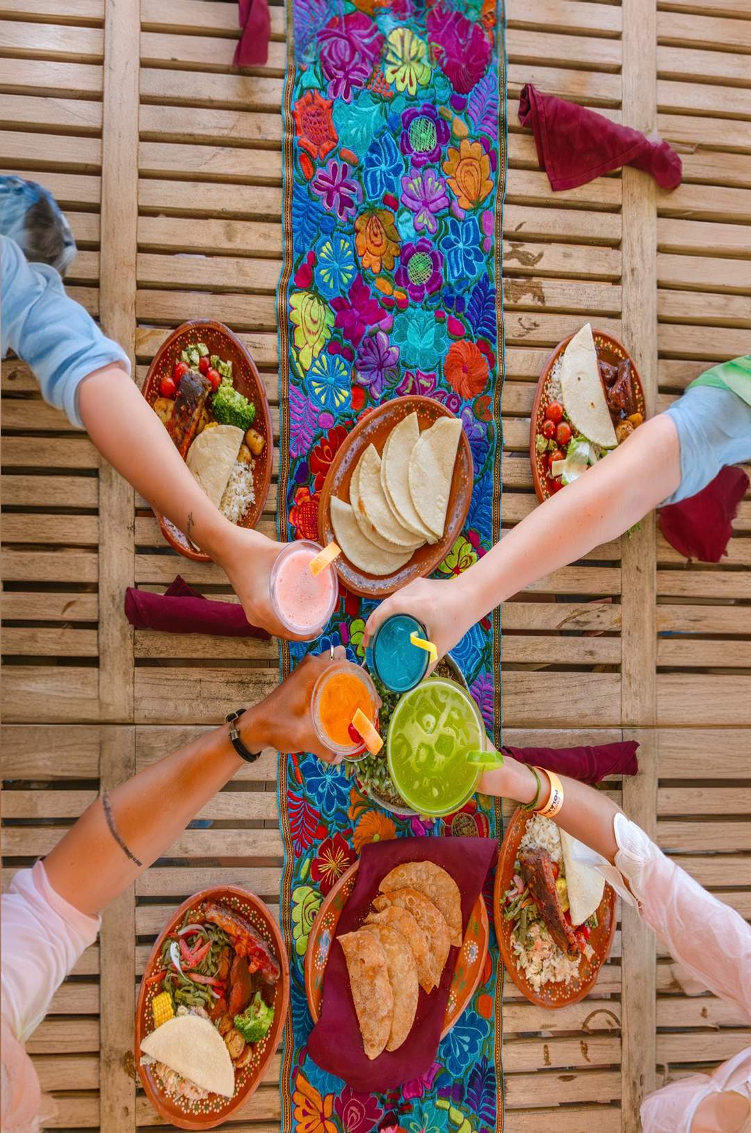 4 persons toasting over a colourful table