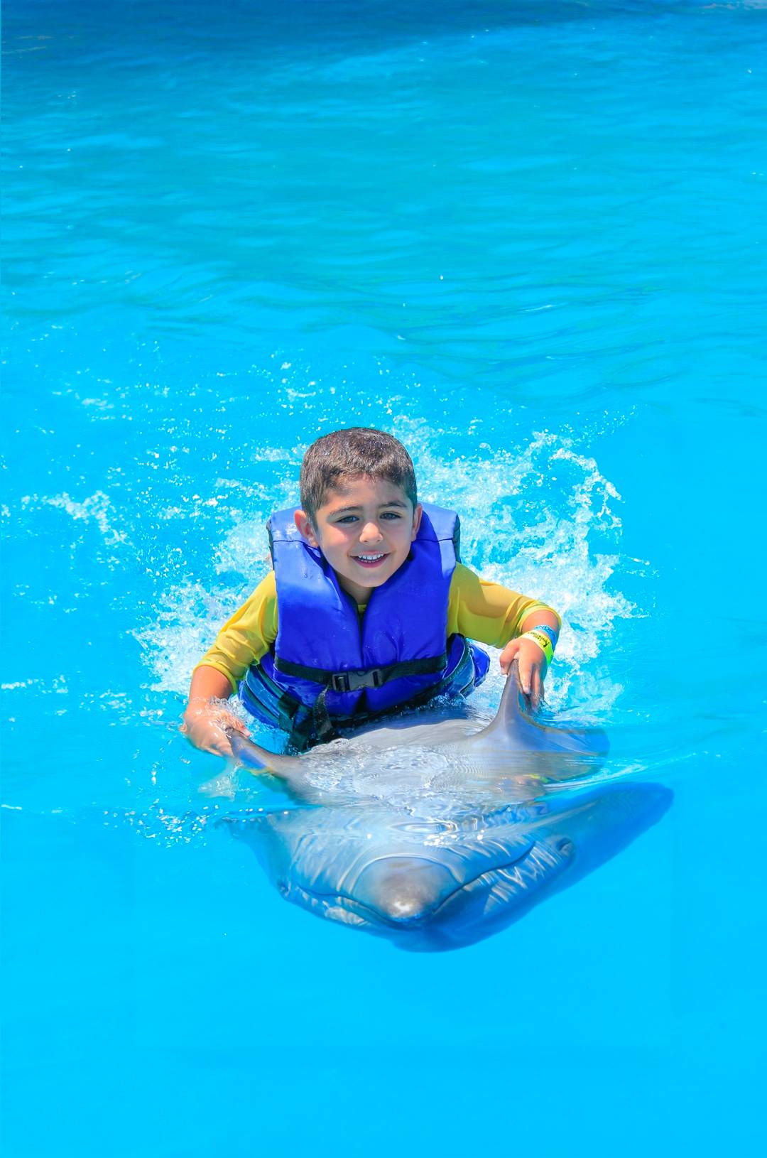 Child enjoying a dolphin swim experience in Cabo San Lucas.