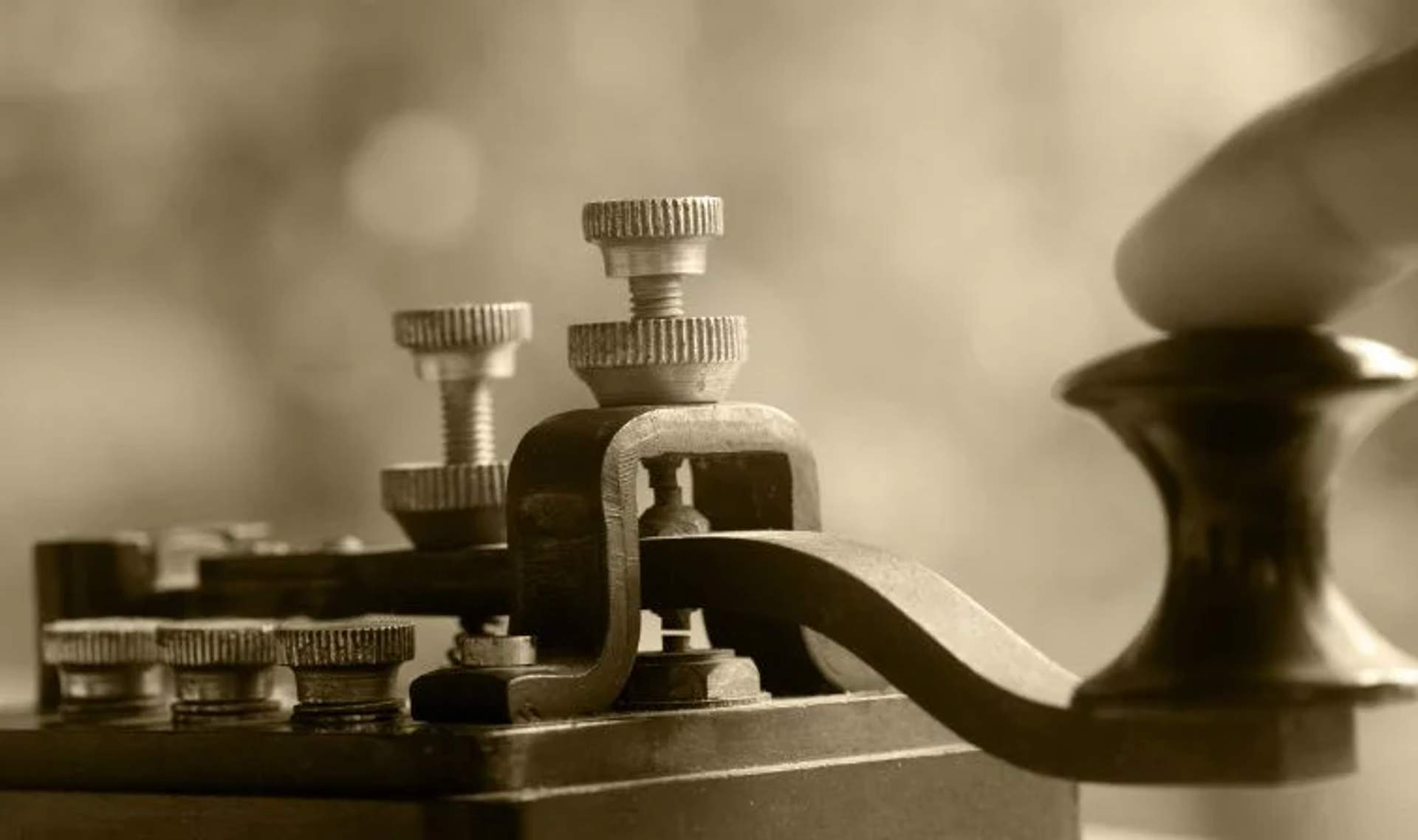 Close-up of an antique telegraph machine with detailed knobs and levers, showcasing early telecommunications technology.