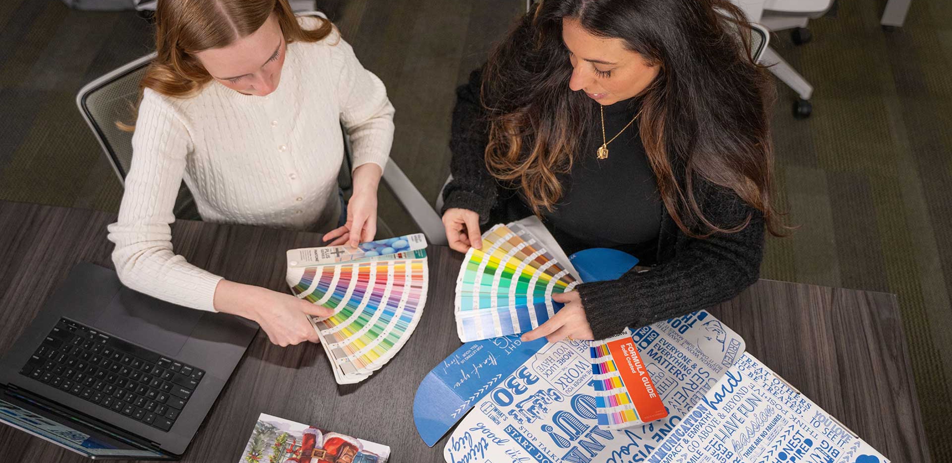 898 Marketing designers reviewing Pantone color swatches and brand style guide materials