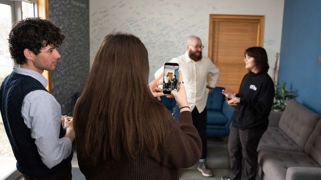 898 Marketing team filming social media content with a smartphone in the office