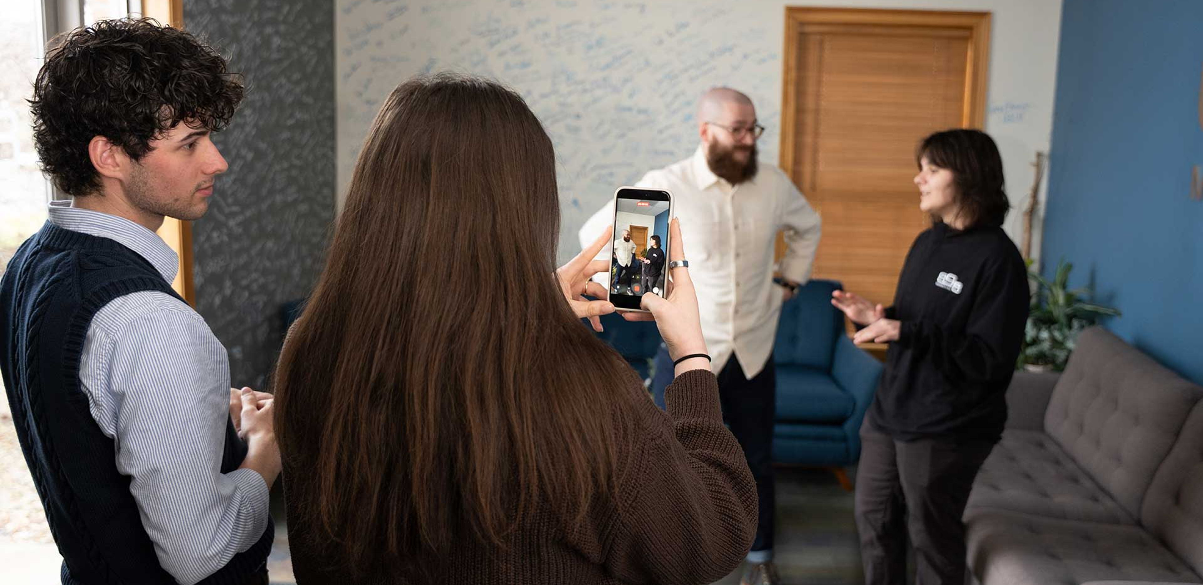 898 Marketing team filming social media content with a smartphone in the office