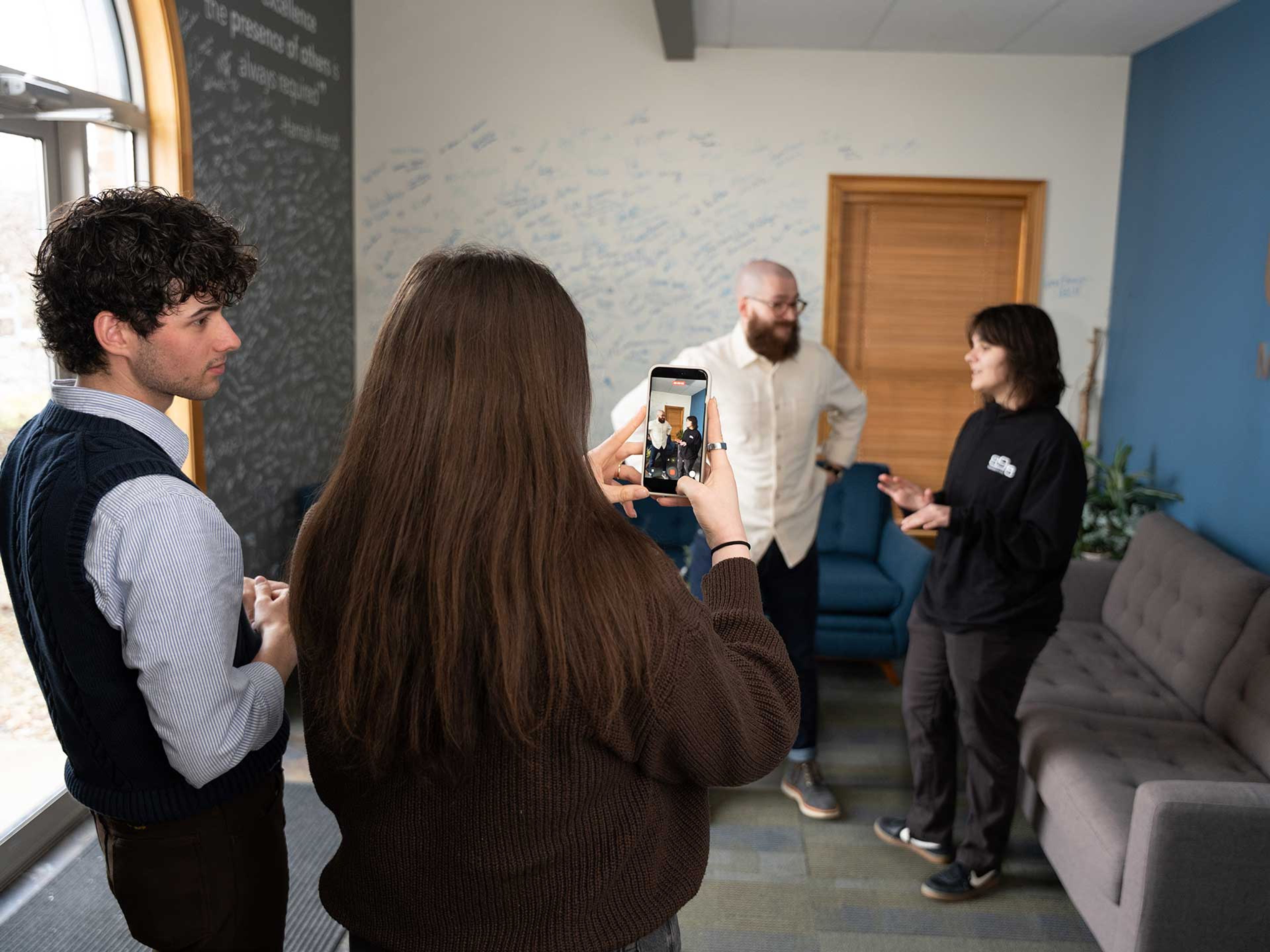898 Marketing team filming social media content with a smartphone in the office