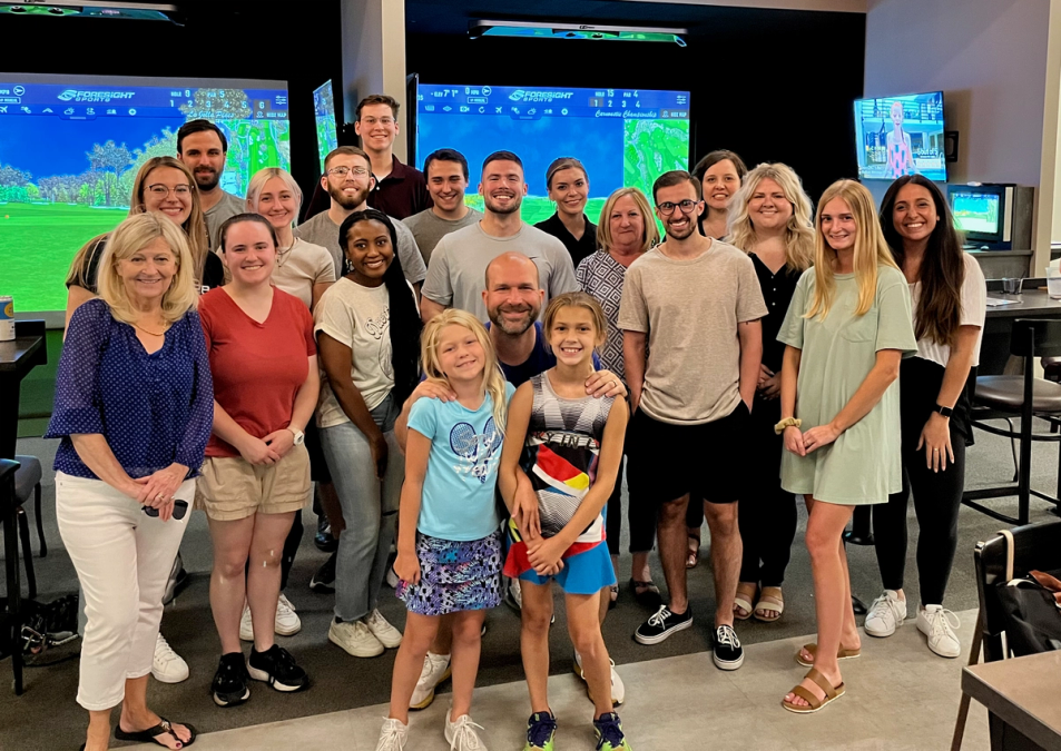 Team photo of 898 marketing in front of golf simulators