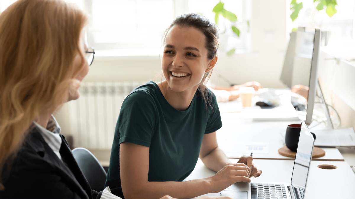 Two women smiling looking at computer screen