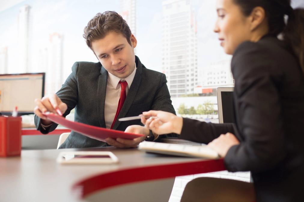 Two professionals looking at folders
