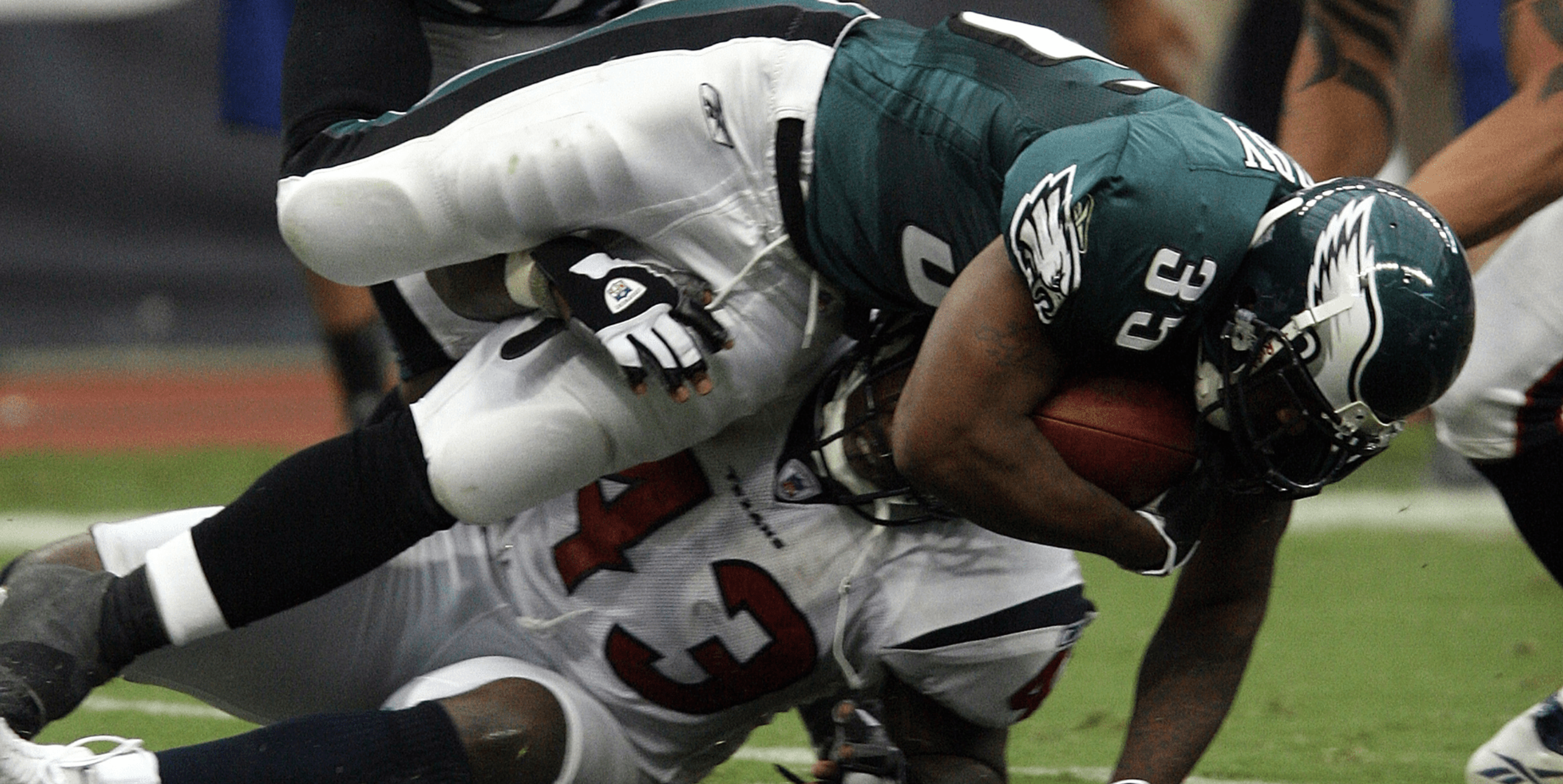 Football players tackling each other
