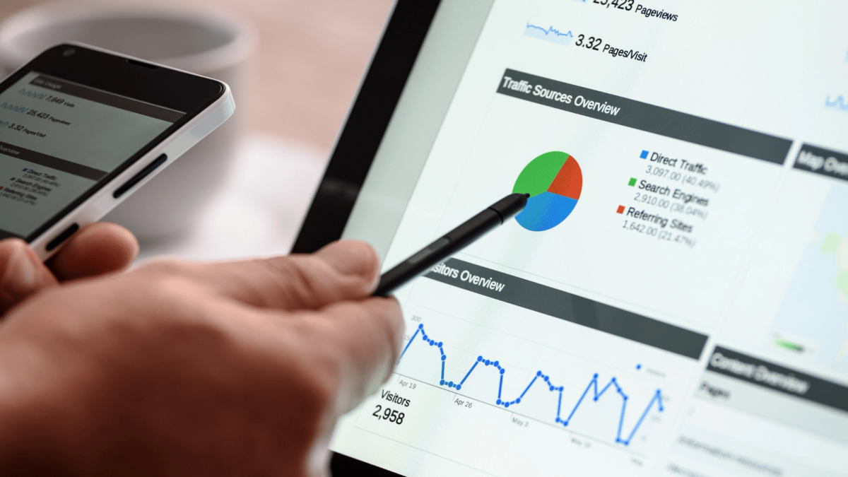 Man holding stylist pointing to pie chart on screen
