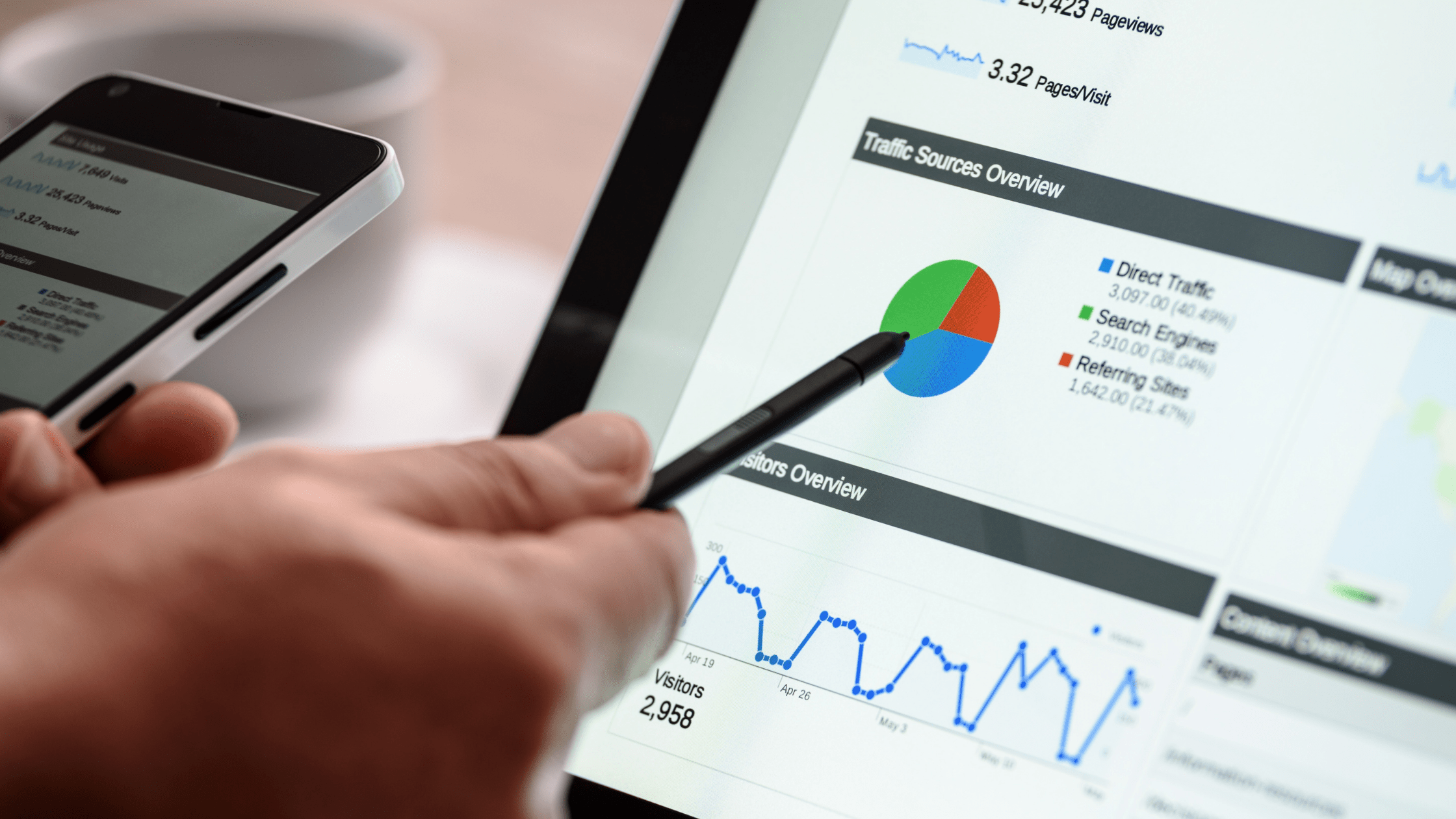 Man holding stylist pointing to pie chart on screen