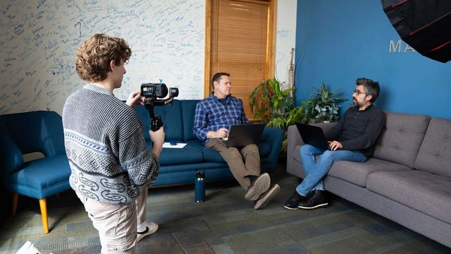 898 Marketing videographer filming a client interview with a gimbal camera setup