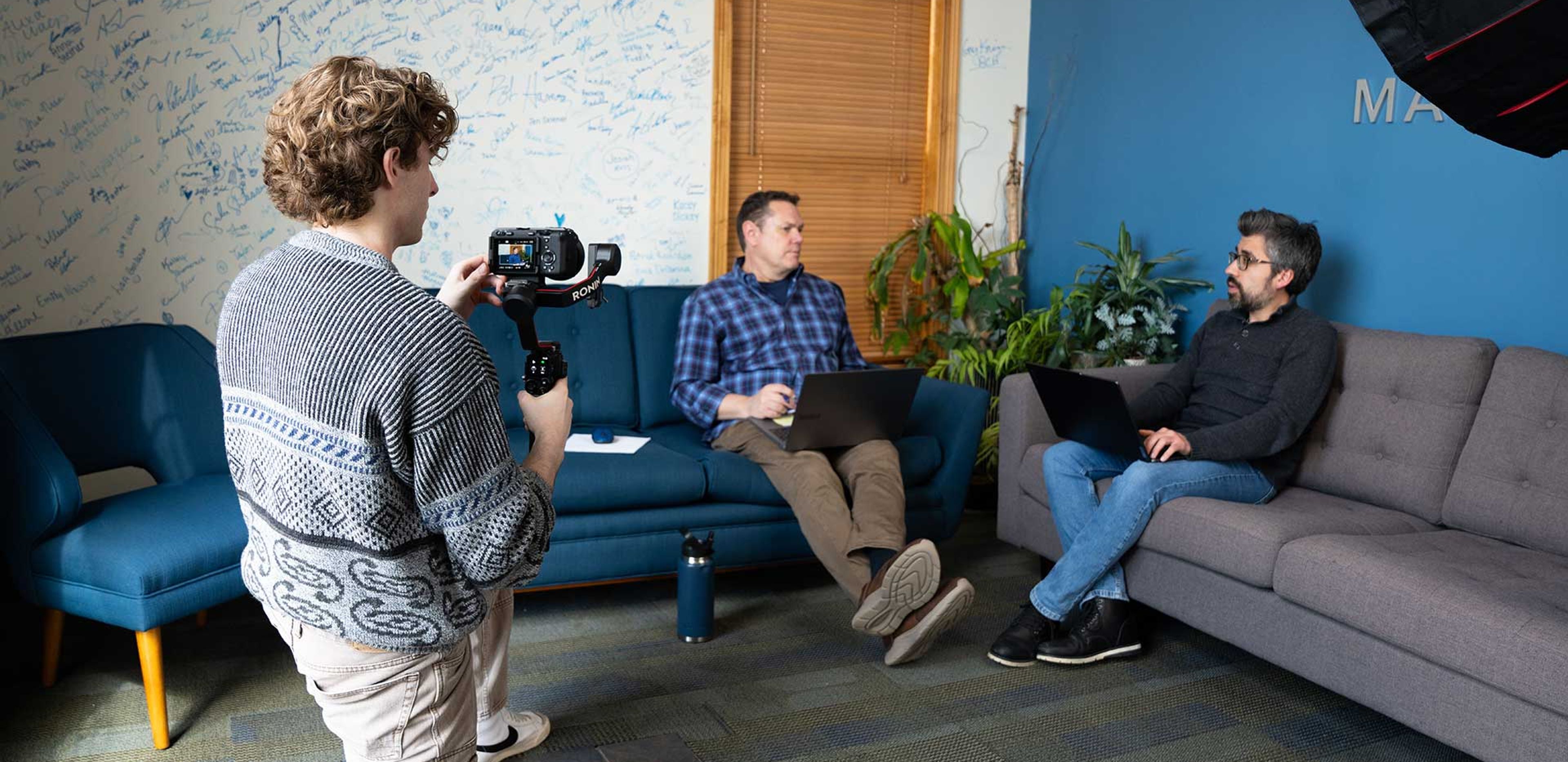 898 Marketing videographer filming a client interview with a gimbal camera setup