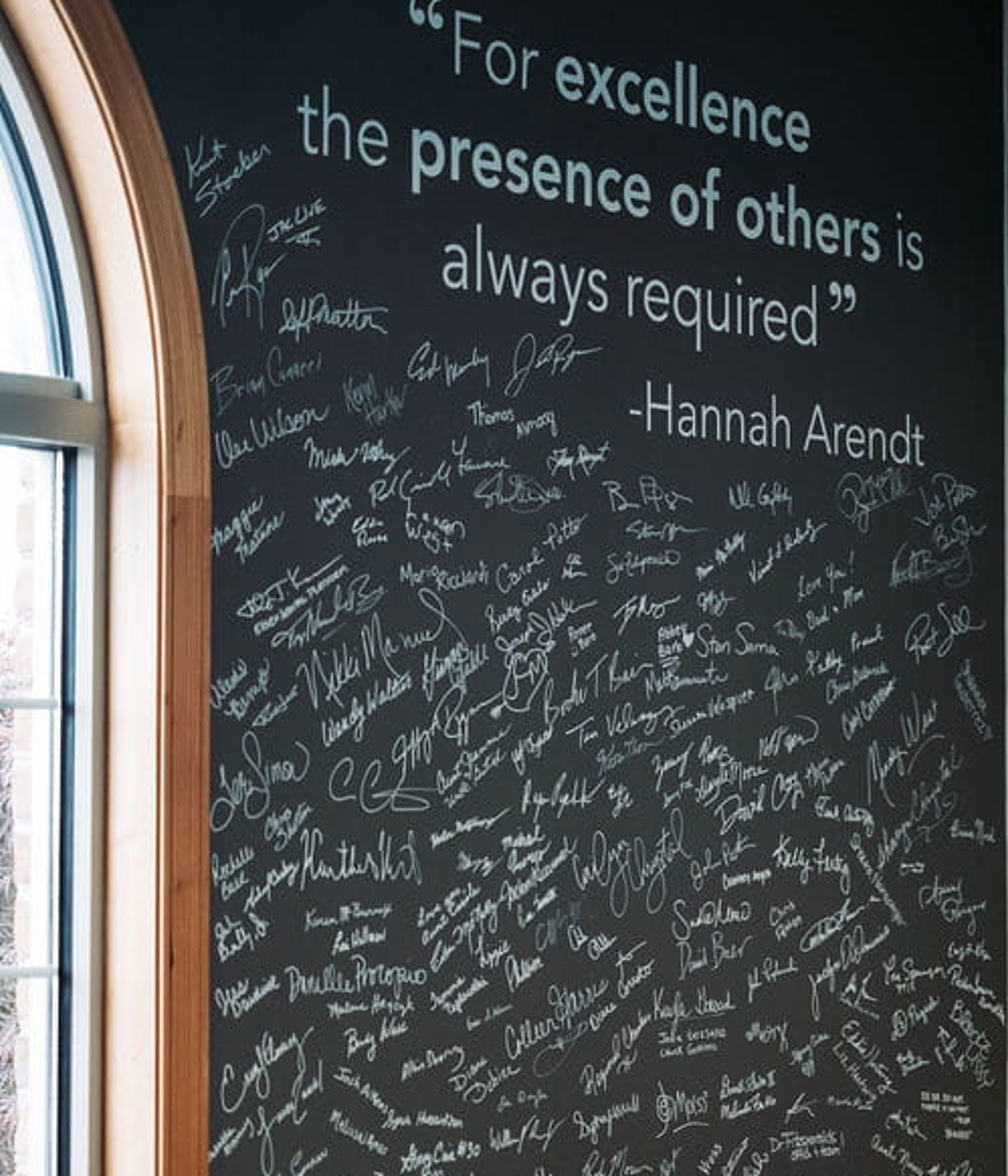 Signature wall at the 898 Marketing office in Canfield. The quote on the wall states "For excellence the presence of others is always required"